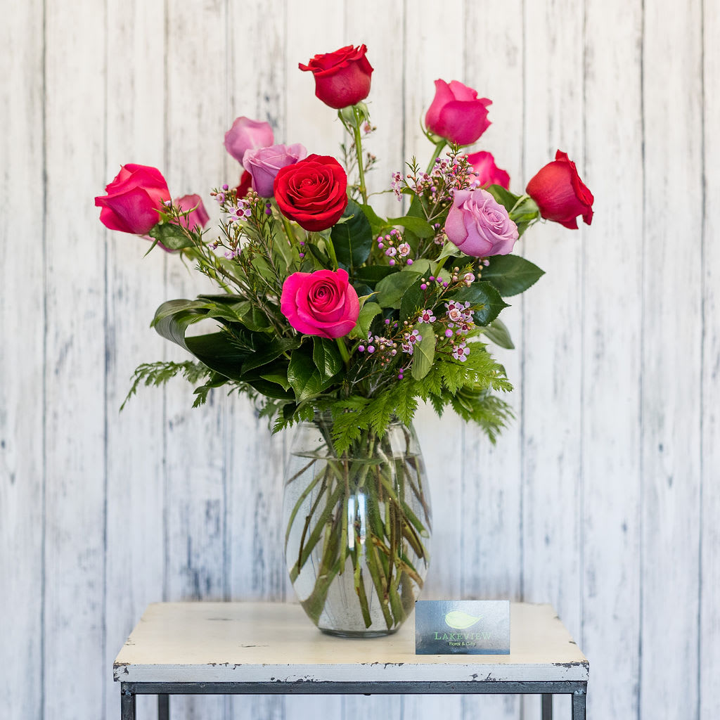 Mademoiselle - Pure femininity!  One dozen red, lavender and hot pink roses are arranged in a classic glass vase.   Approximate Dimensions: 18" T x 14" W