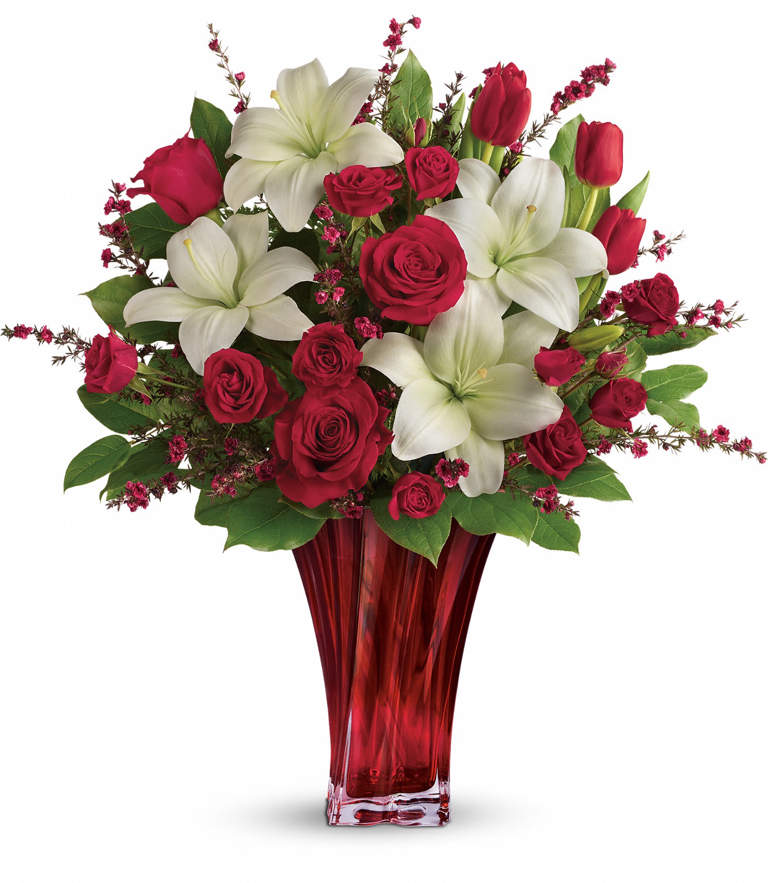 Love's Passion Bouquet by Teleflora - This passionate display of red roses, red spray roses, red tulips, and white asiatic lilies is accented with red leptospermum, leatherleaf fern, and lemon leaf. Delivered in a Love's Passion vase. Approximately 21 1/2" W x 22 3/4" H