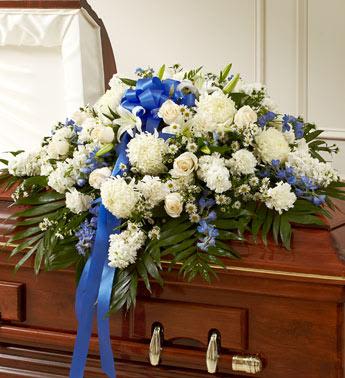 Cherished Memories Half Casket Cover-Blue &amp; White - Send the perfect expression of your love and a tribute to a beautiful life.  Features gorgeous long stem white roses, hybrid lilies, football mum, blue delphinium and more. Traditionally sent by the immediate family to the funeral home Our florists use only the freshest flowers available, so colors and varieties may vary Arrangement measures approximately 18"H x 38"L x 28"D