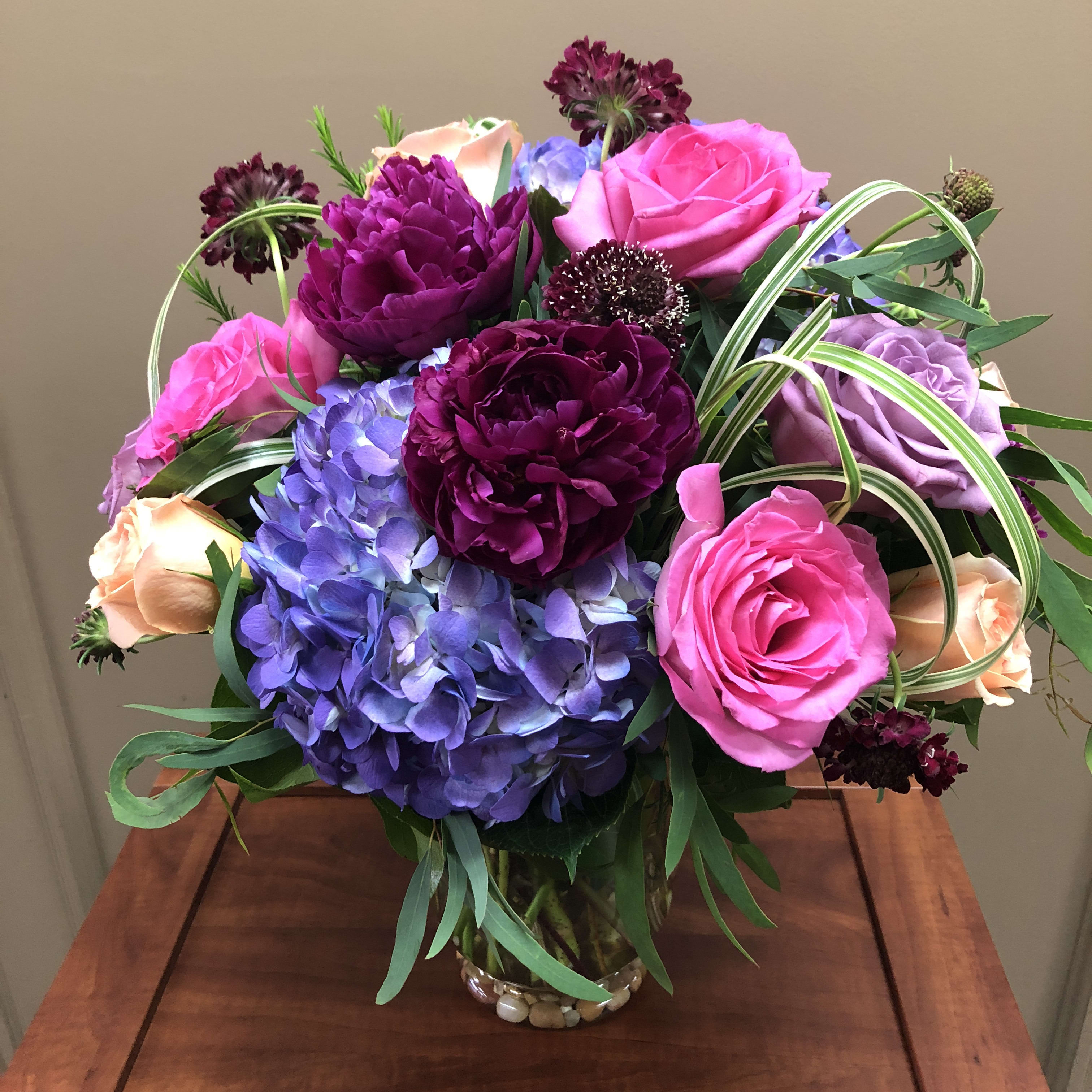 Jewel of the Valley - Send all their favorites - all wrapped up in one gorgeous design! Featuring hydrangea, peonies, roses and scabiosa - finished with eucalyptus and lily grass loops. 