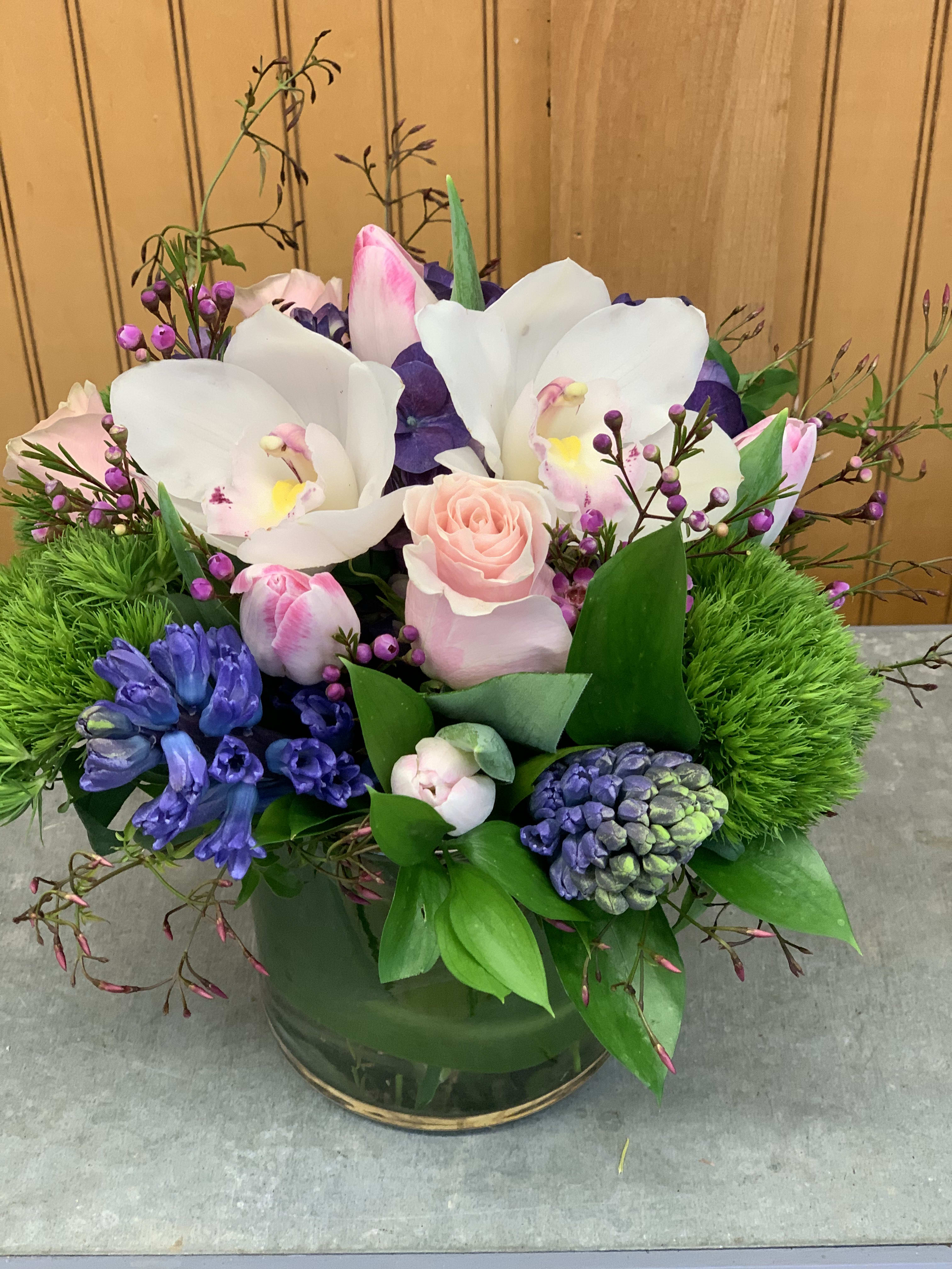 Capri - Hyacinths, tulips, roses and orchids in a cylinder vase. 
