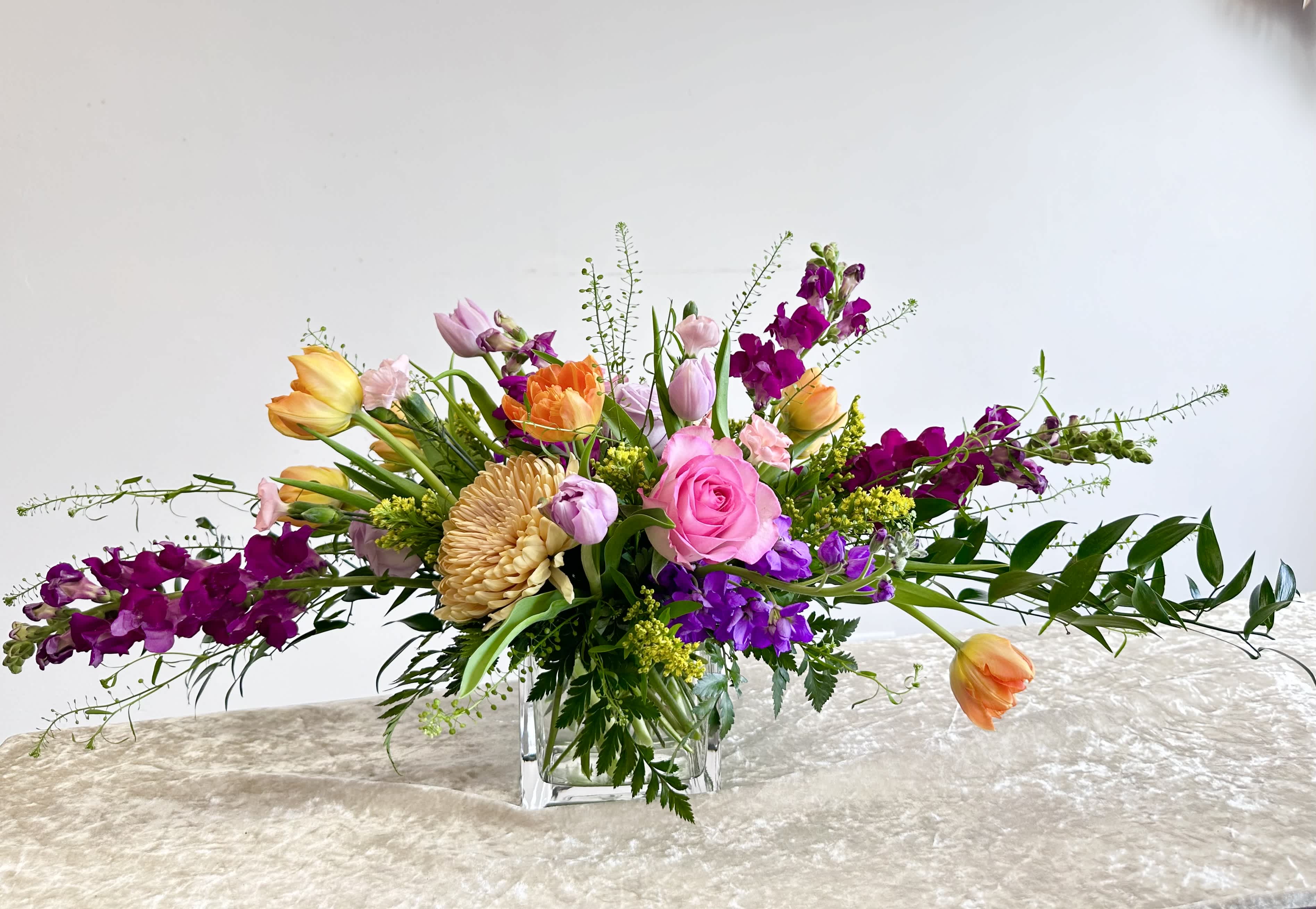 Garden of Desire - This garden of desire includes a spring variety of roses, tulips, snapdragons and more!.  Artfully arranged in a glass cube and makes a perfect centerpiece! If a flower pictured is unavailable we will substitute with another comparable seasonal flower.