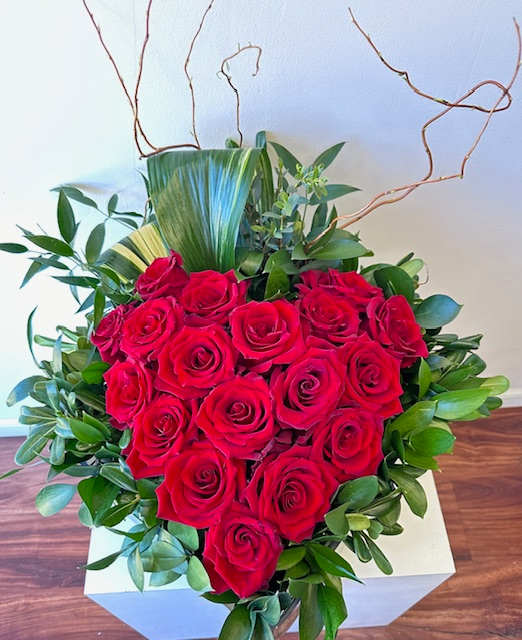 Love You More! - This masterpiece will surely raise their pulse!  A gorgeous design of 18 Red Roses arranged in a large glass box accented with willow and greenery. 