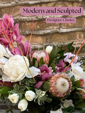 Modern and Sculpted - Designer Choice - Our designers will create a beautiful arrangement with the most magnificent blooms mother nature has to offer. While we cannot guarantee a specific flower type, we can promise that your arrangement will be stunning, fresh and one of a kind!  Flowers and containers may not reflect exactly as pictured but will stay within the color palette you have requested.
