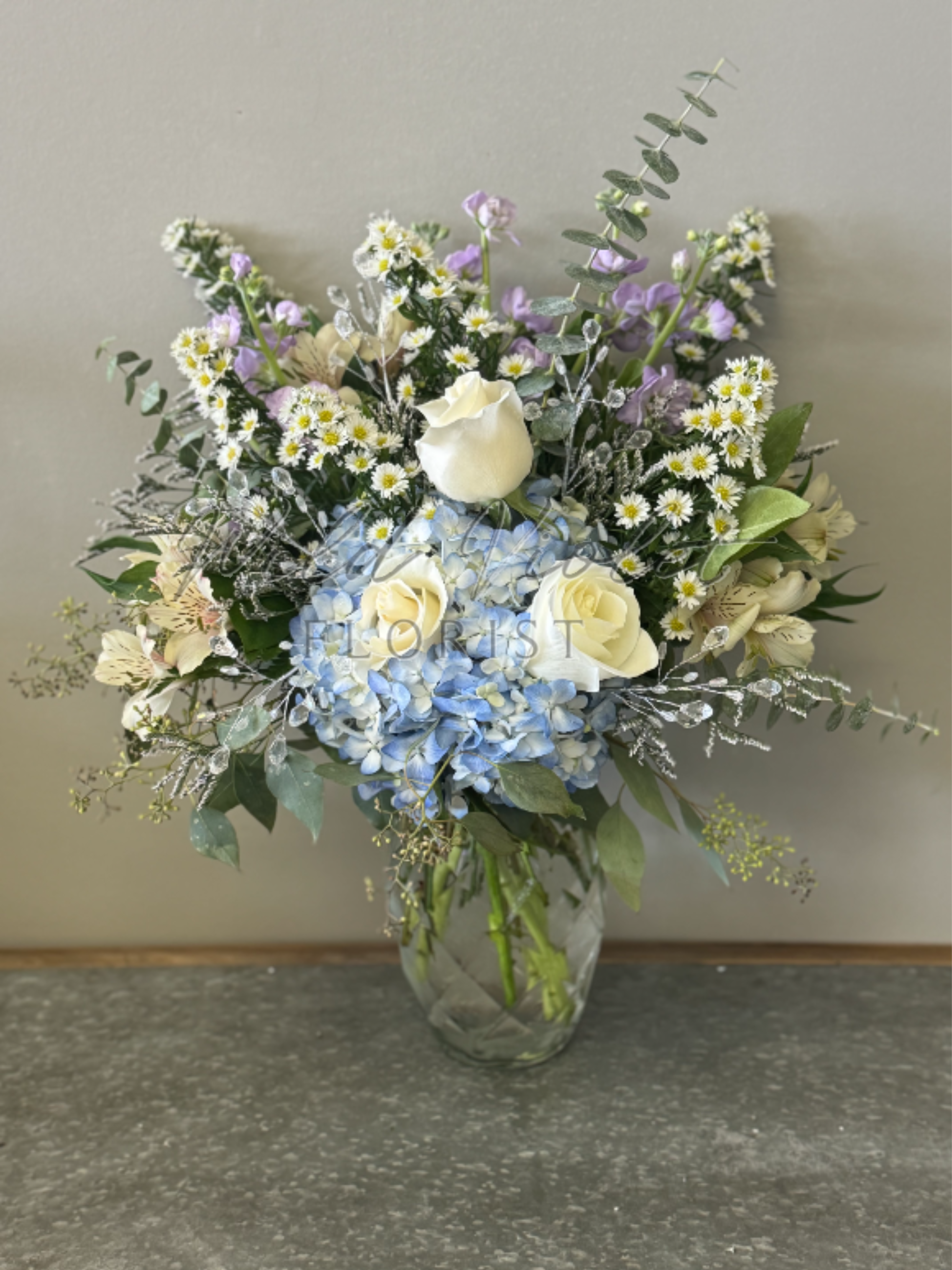 April Diamond Bouquet - Birthstone Collection What better way to celebrate your loved one's birthday than with our April Diamond Bouquet! Hand-designed with a stunning gathering of pastel blooms, lush greenery and diamond touches, it’s a thoughtful sentiment filled with the strength and everlasting love of a diamond stone.  ATTENTION! If you are ordering this arrangement on a different month other than what it's respected month is, there will be substitutions for certain flowers depending on seasonal availability. We will stay within the same color scheme and design style!  PLEASE NOTE: Florist reserves the right to make modifications to the design based on seasonality and accessibility of blooms and vases. Any modifications made will honor the palette, intent, and feeling of the pictured design. Contact floral designer directly with any specifications or concerns.