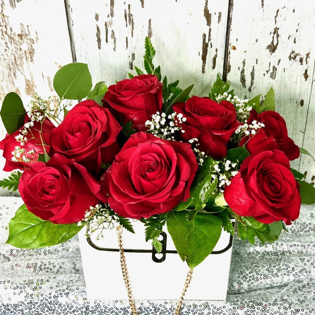 In the Bag - VAL0007 - In the Bag - VAL0007 Express timeless love with this elegant bouquet of rich red roses, beautifully arranged in a chic white designer box accented with delicate baby’s breath and lush greenery. Perfect for Valentine’s Day romance, Mother’s Day appreciation, anniversaries, or any occasion that celebrates passion and devotion. This premium floral gift combines classic beauty with modern style, making it an unforgettable gesture of love.