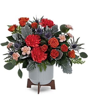 Teleflora's Retro Brights Bouquet - A bold gift for the best dad! Make his special day even more memorable with this bright orange bouquet in a sleek ceramic planter. Orange spray roses, orange carnations, miniature peach carnations, blue eryngium and dusty miller are accented with silver dollar eucalyptus and leatherleaf fern. Delivered in a Classic Contemporary planter.