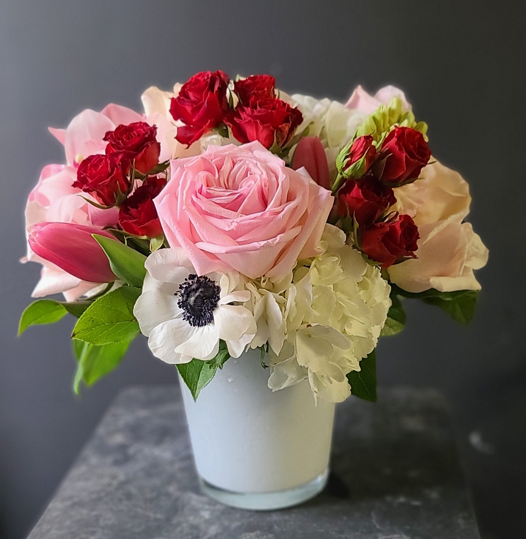 EVERLASTING LOVE  - A sweet arrangement of spray roses, roses, hydrangea, tulips, and anemones. 