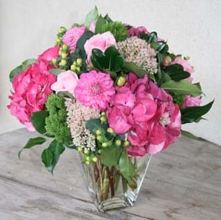Raspberry Delight  - Looking for something out of the ordinary? Then this is a fabulous treat! Pink hydrangea, pink roses, pink gerberas, pink sedum, green berries, and green trachellium fill a beautiful clear vase. This gift is sure to stand out! Tax free. Same day hand delivery.