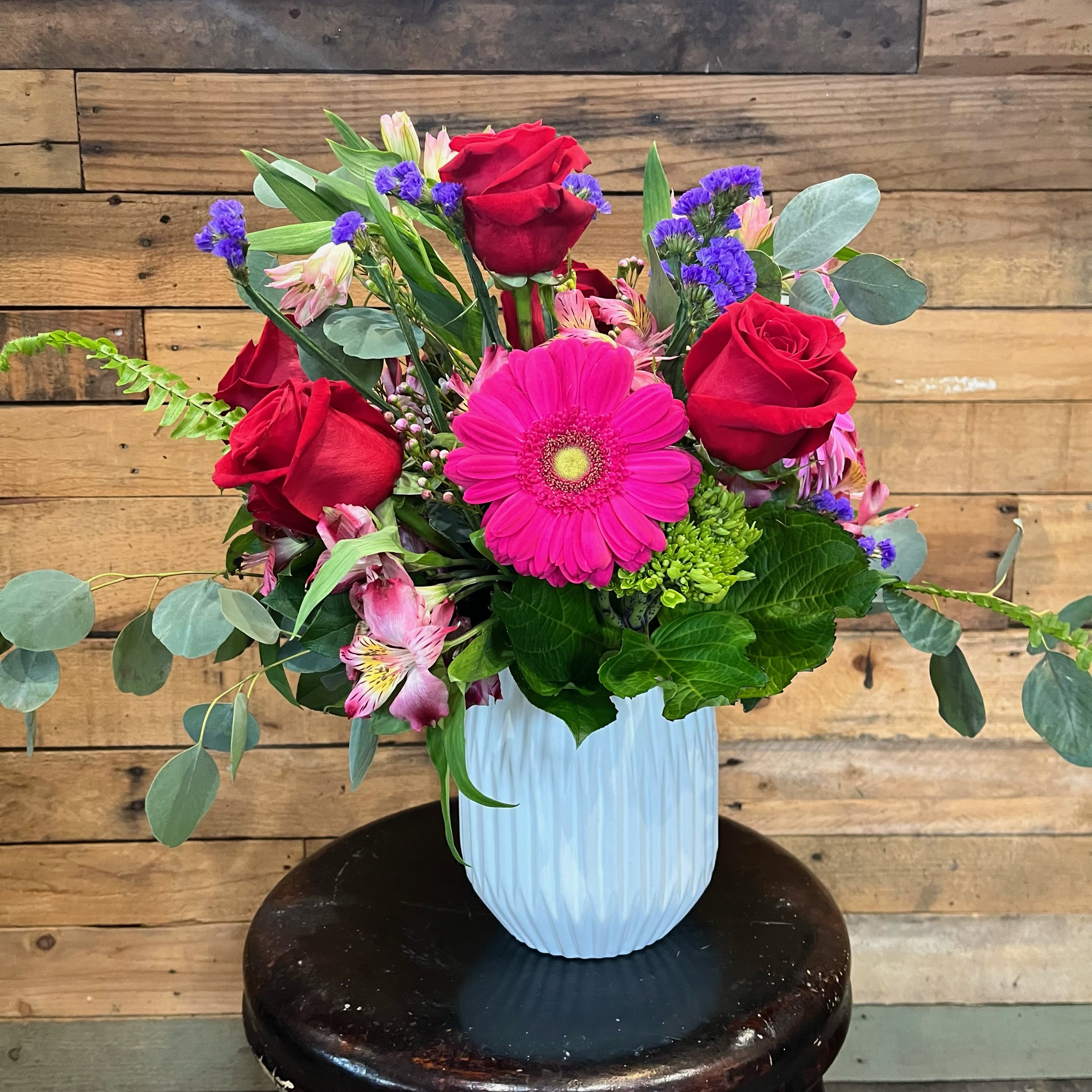 Valentine Kiss  - Grab this sweet design overflowing with color for your special someone! Gerbers, Roses, and more complete this arrangement. Flower &amp; Container substitutions apply.