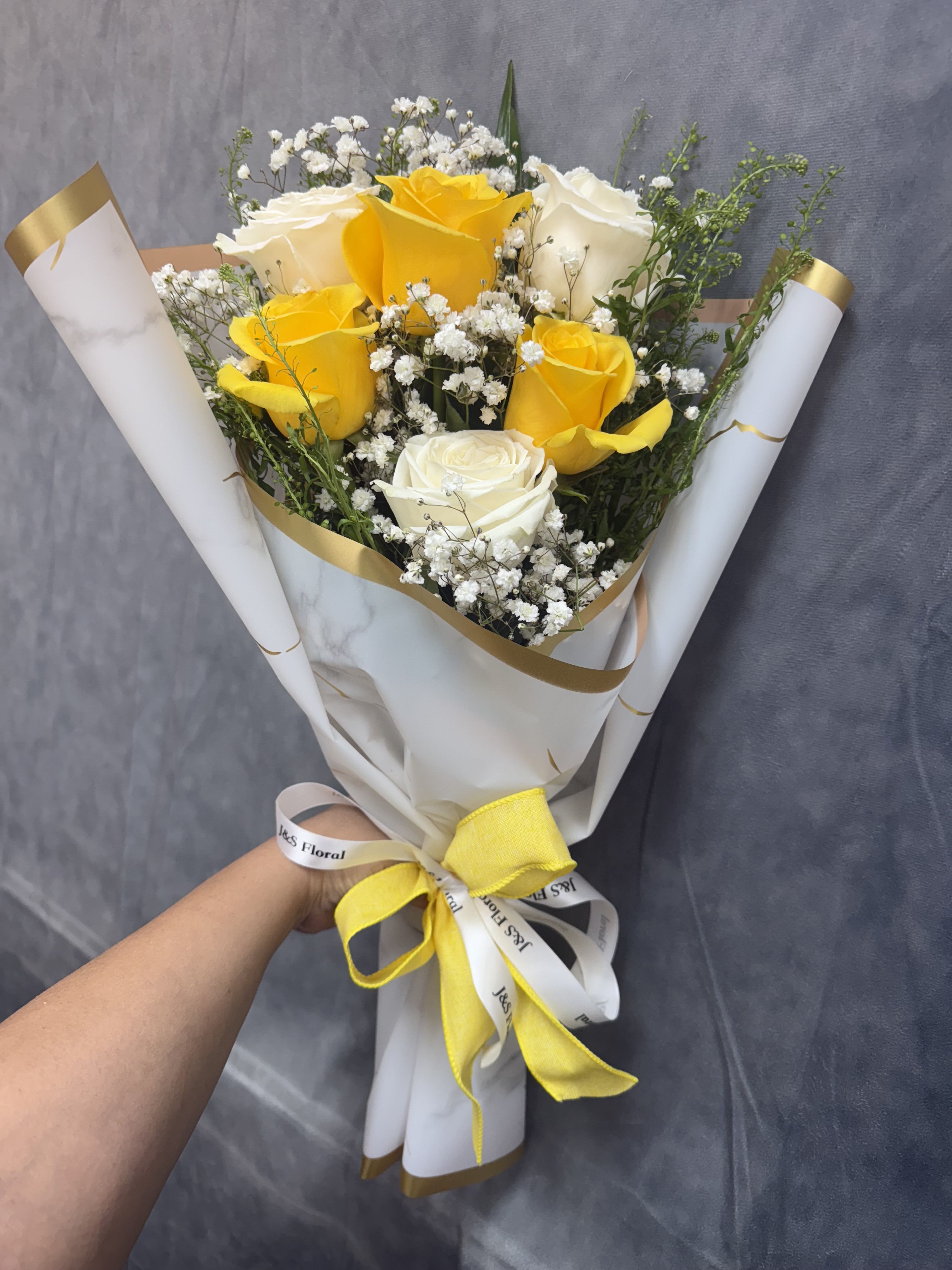 Yellow white layered roses bouquet - A cheerful layered bouquet of half dozen yellow and white roses accented with baby’s breath symbolizing friendship and happiness makes this bouquet a perfect gift for any occasion 