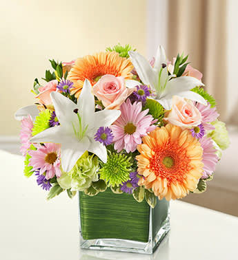Healing Tears - Multicolor Pastel - Product ID: 95432  Express your sympathy and compassion perfectly with this beautiful multicolored arrangement of pastel blooms such as roses, Gerberas, lilies, carnations and more. A comforting tribute for the home or memorial service. Elegant pastel-toned arrangement of roses, Gerbera daisies, lilies, carnations, monte casino and poms, accented with variegated pittosporum and myrtle Artistically designed by our florists in a classic clear glass cube vase lined with a Ti leaf ribbon; vase measures 5"H x 5"D Appropriate for the service or for sending to the home or office of friends and family members Large arrangement measures approximately 11"H x 11"L Medium arrangement measures approximately 10"H x 10"L Small arrangement does not include roses and measures approximately 9"H x 9"L Our florists hand-design each arrangement, so colors, varieties, and container may vary due to local availability Lilies may arrive in bud form and will open to full beauty over the next 2-3 days