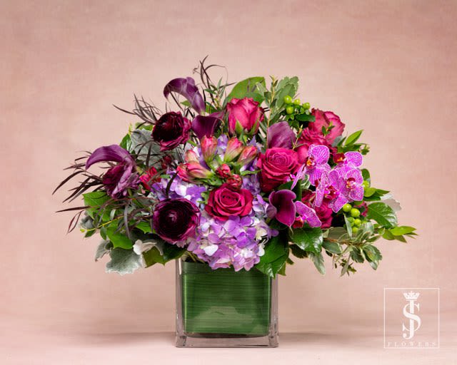 Lavender Love  - Pastel lavender fades to ultra violet in this striking new design. A brilliant medley of delicate Ranunculus, roses, orchids, and purple hydrangea are met by some strands of wild greenery branching out in every direction