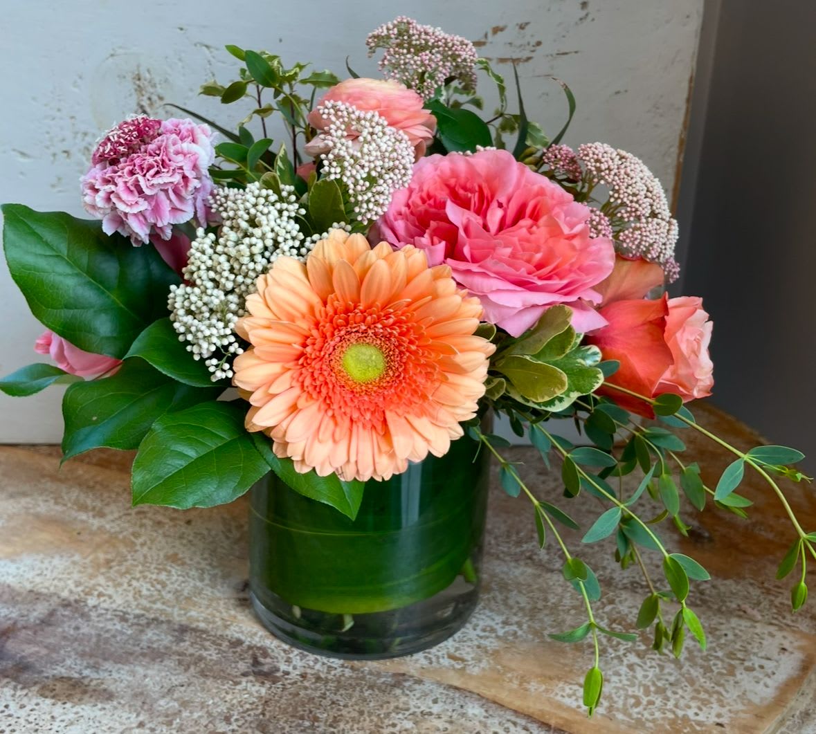 Just Peachy - Roses, ranunculus, gerbera daisies and rice flower in shades of peach and pink in a vase. 