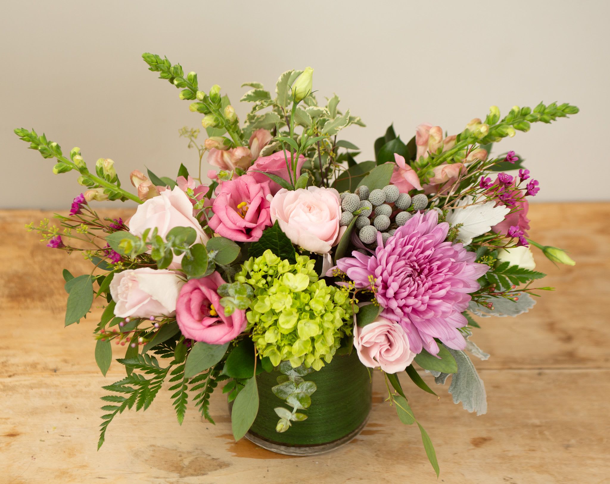 Blush Classic - A sophisticated beauty sure to bring joy to a friend or loved one.  Bursting with blushing roses and seasonal blush pink hued blooms, accented with soft greens and white florals. Image shown is deluxe size approx 10x12. 