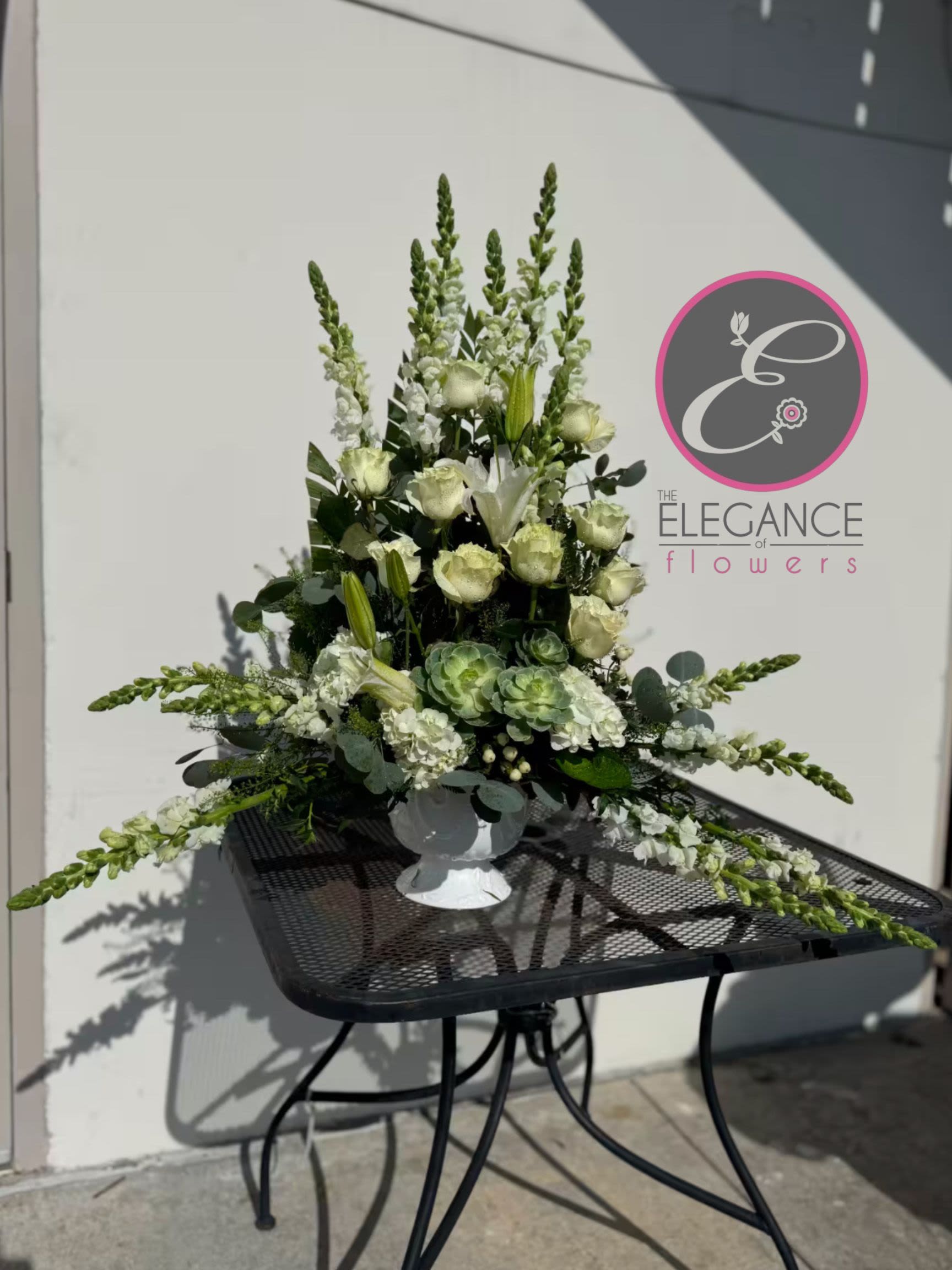 Pedestal Arrangement #3 - A sympathy pedestal arrangement offers a heartfelt expression of condolence, featuring a carefully curated selection of serene and elegant blooms. Designed to convey comfort and peace, each arrangement is thoughtfully crafted with soft hues and gentle fragrances, providing a soothing presence during times of loss.