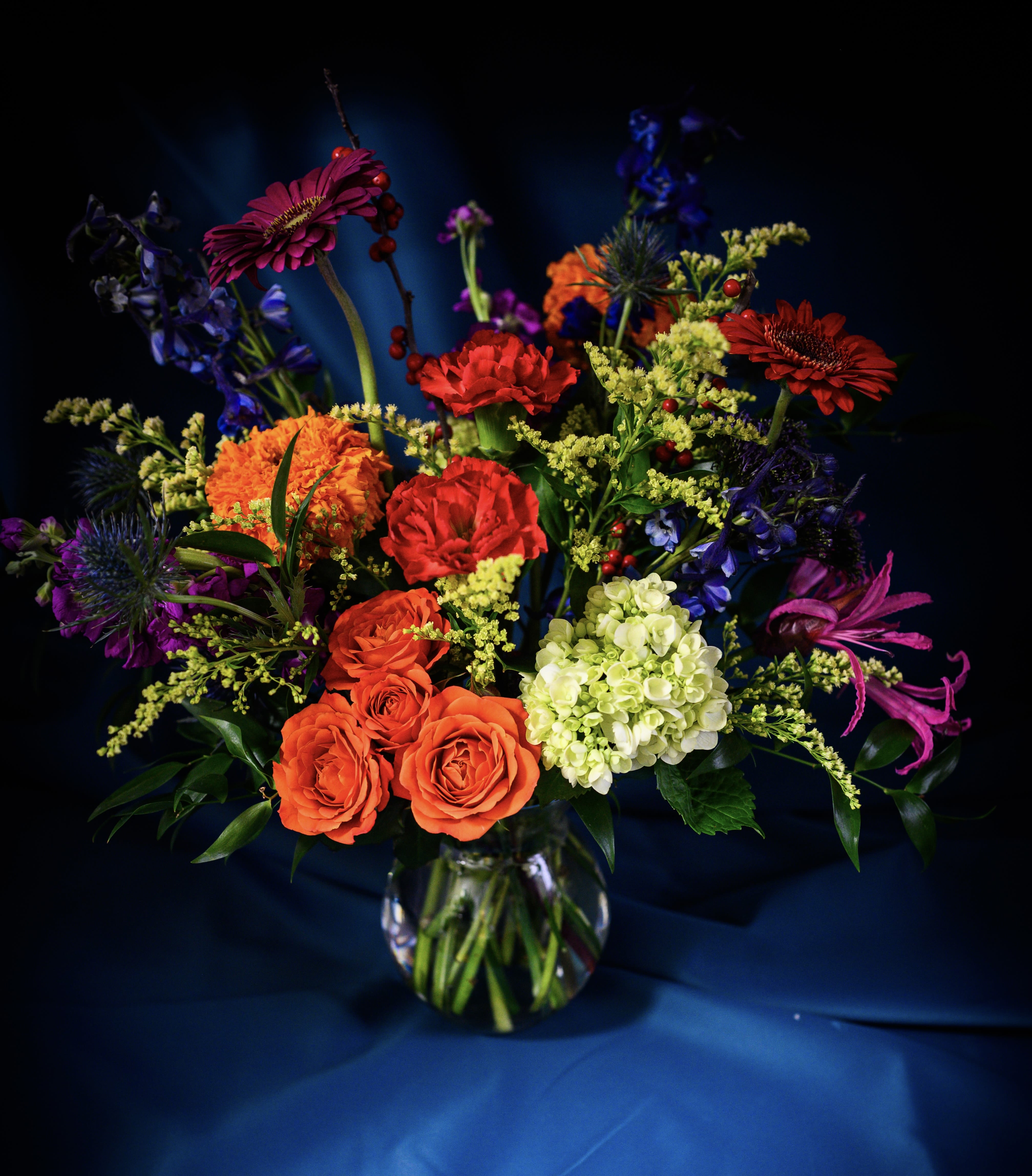 Designer's Choice, "DUTCH MASTERS" Vased Arrangement  (Brights, Primary Colors) - This bold and bright bouquet of lush flowers is reminiscent of a Dutch Masters painting. Seasonal bulb flowers will be debuting alongside roses, ranunculus and frilly carnations. A primary palette of blues, reds and yellows will be accented with complimentary hues based on availability and the designer's whims!