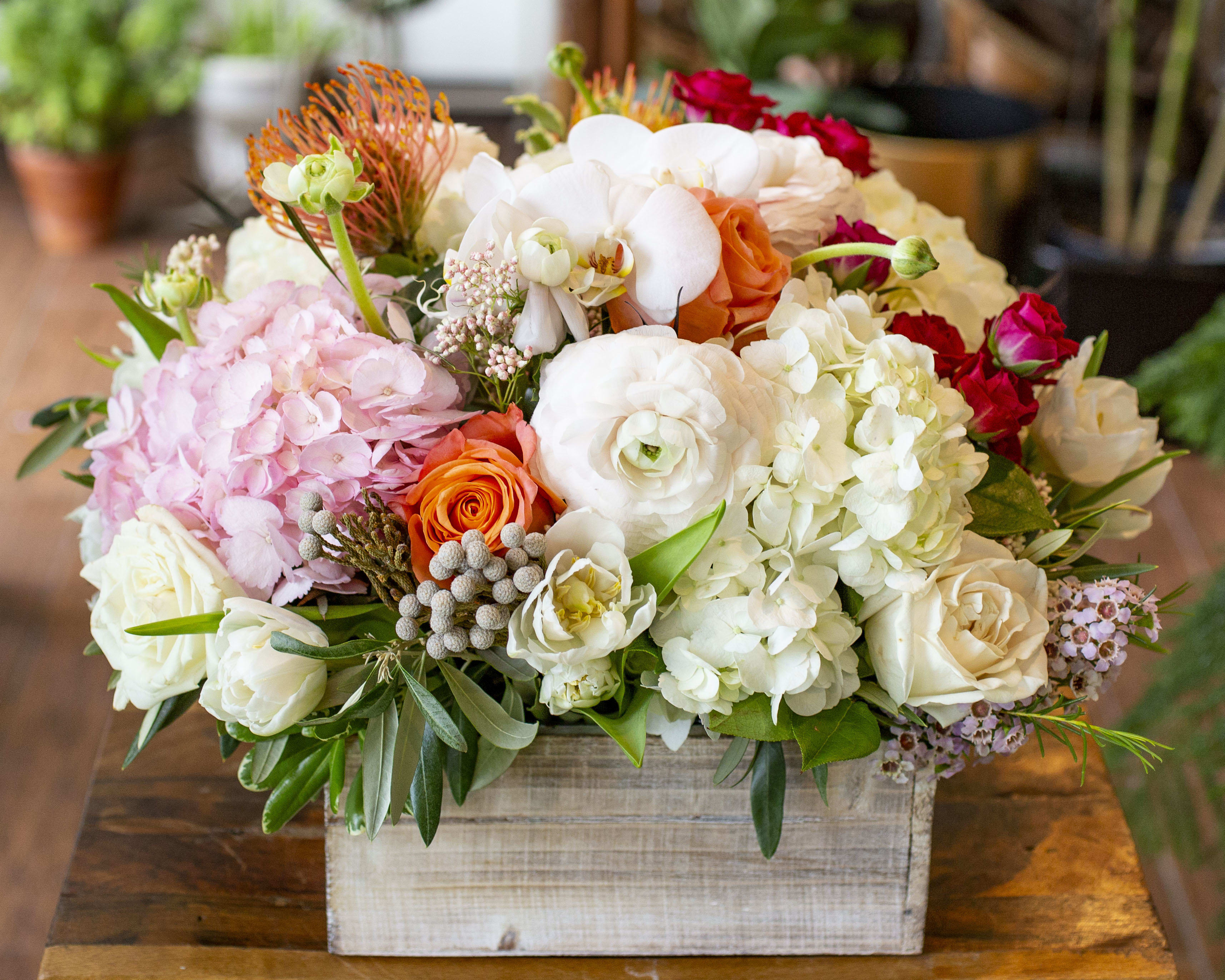 Colleen - Soft and fluffy blooms contrasted with accents of pin-cushion protea and brunia, arranged in a large whitewash wooden box. *Some flowers may be out of season and would require substitution.
