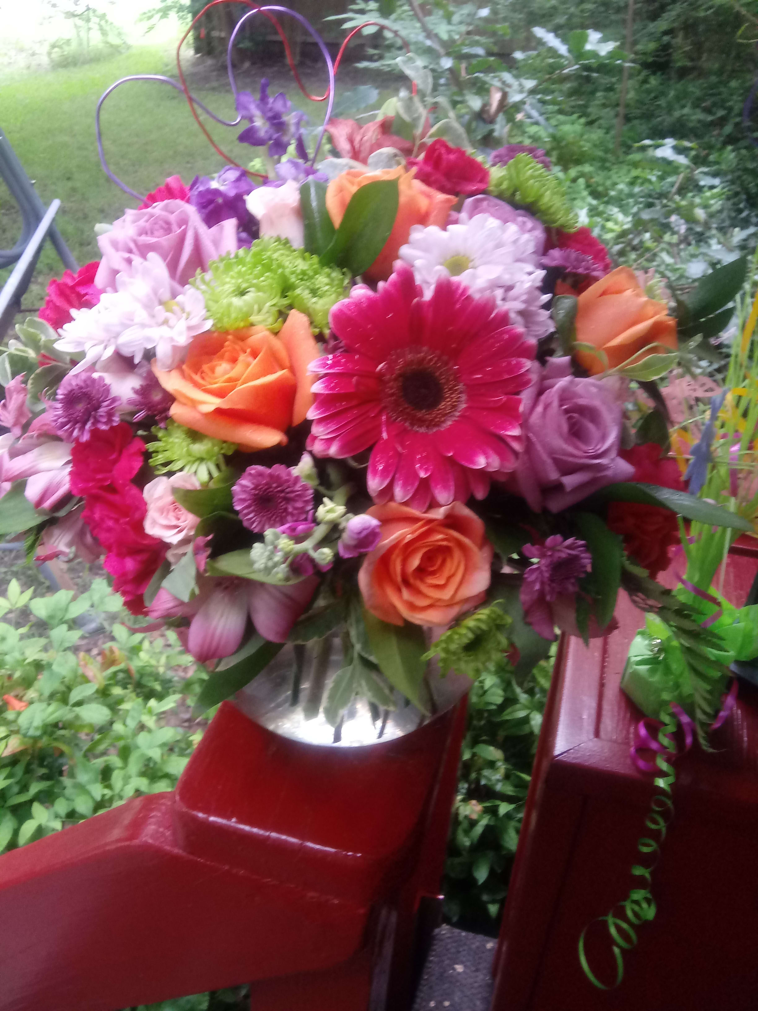 Sweetness - A lovely mixture of pretty fresh cut pink, purple, lavender and orange blooms. This floral design would be a sweet sentiment to be sent for a birthday, baby, get well or just because! 