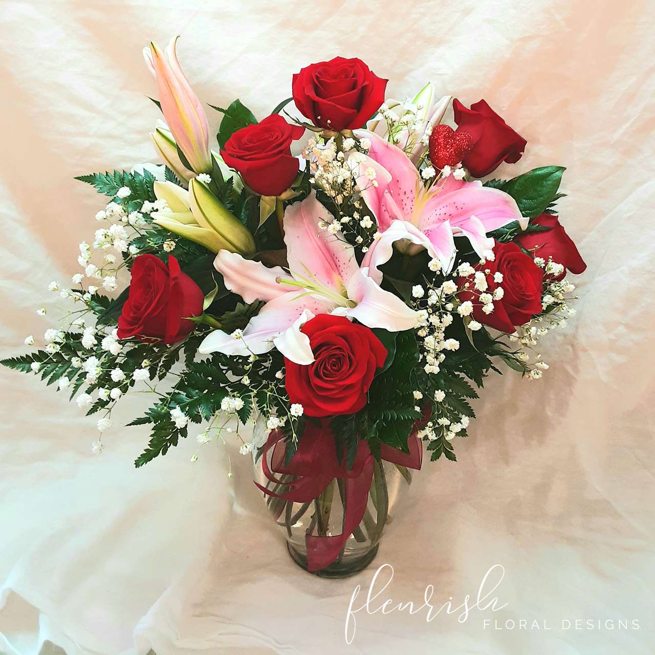 Rose Lily - A delicious arrangement of red roses and lilies displayed in a vase