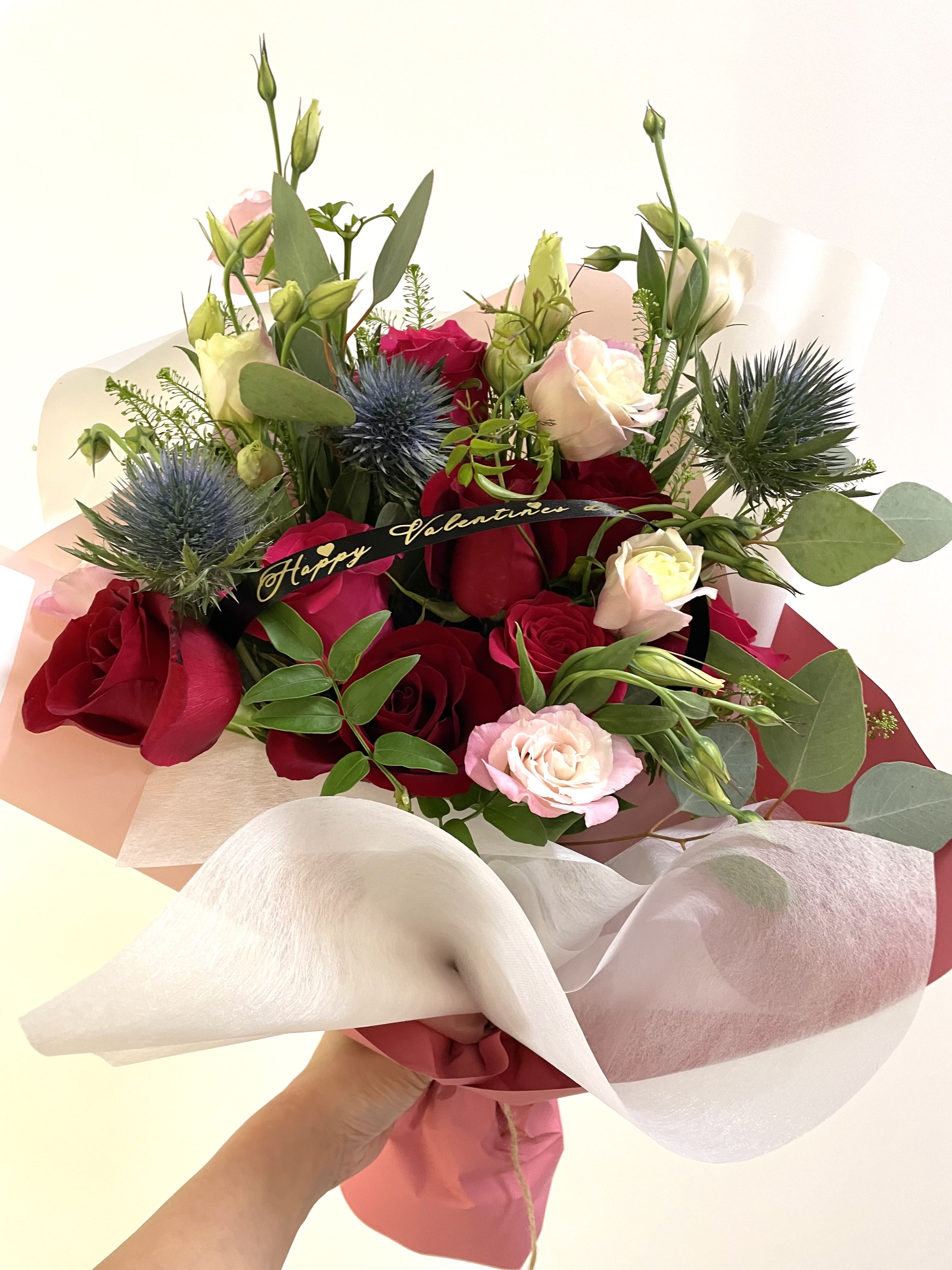 Victoria Blooms  - This beautiful hand-tied bouquet features vibrant red roses, soft pink blooms, and elegant greenery, making it the perfect way to express love and warm sentiments. Ideal for special occasions or simply celebrating everyday moments. *Please note: The vase is not included.