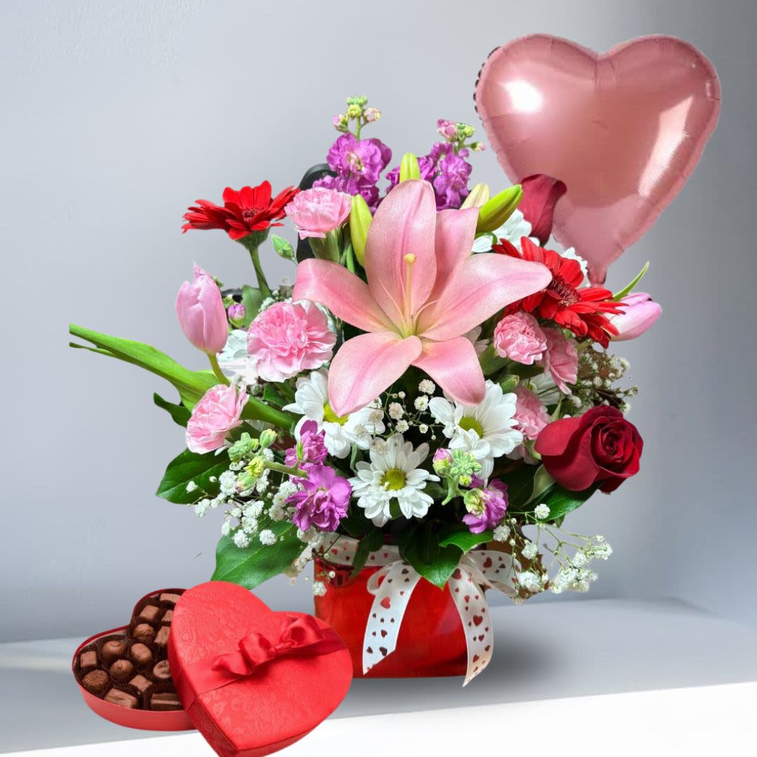 The Juliet Package - Recipe: Pink Lilies, Red Roses, Purple Stock, Red Gerbera Daisies, Pink Tulips, Daisies, and Pink Carnations with medium size chocolates and a heart-shaped mylar balloon. Availability: All year round Design View: All Facing View Photo shown: Standard 