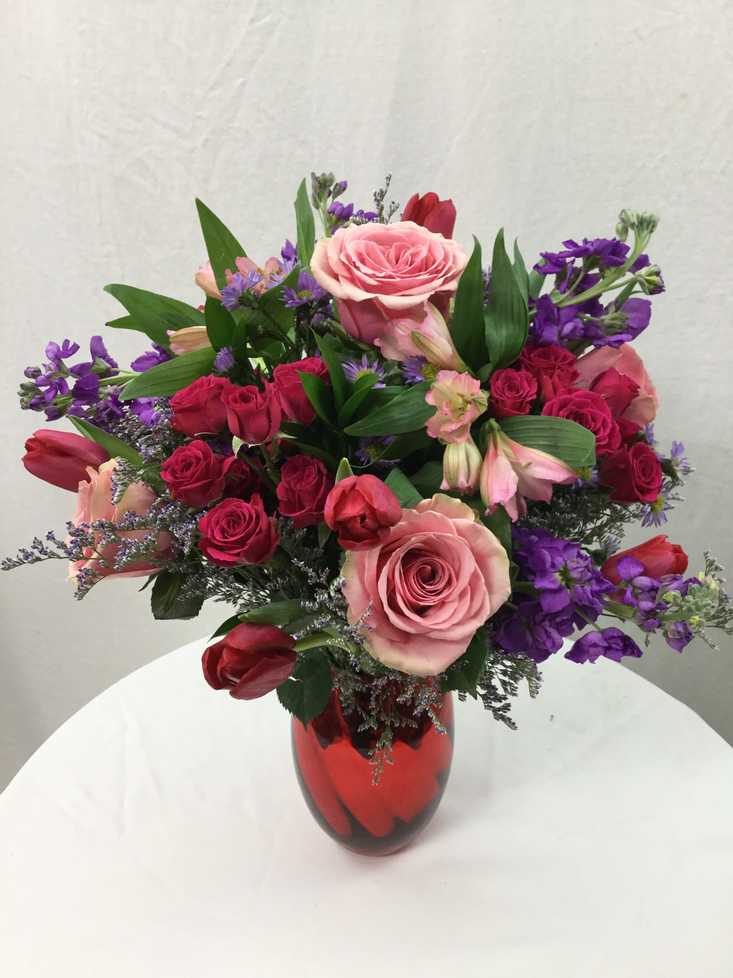 Valentine's Day Bouquet - This stunning bouquet makes for a wonderful gift during the Valentine's Day Week. Full of fresh blooms, greenery and a beautiful keepsake vase, they will be smiling all week long! Due to possible manufacturing delays due to covid, vase may be substituted in the form of a clear glass vase topped off with a red bow.