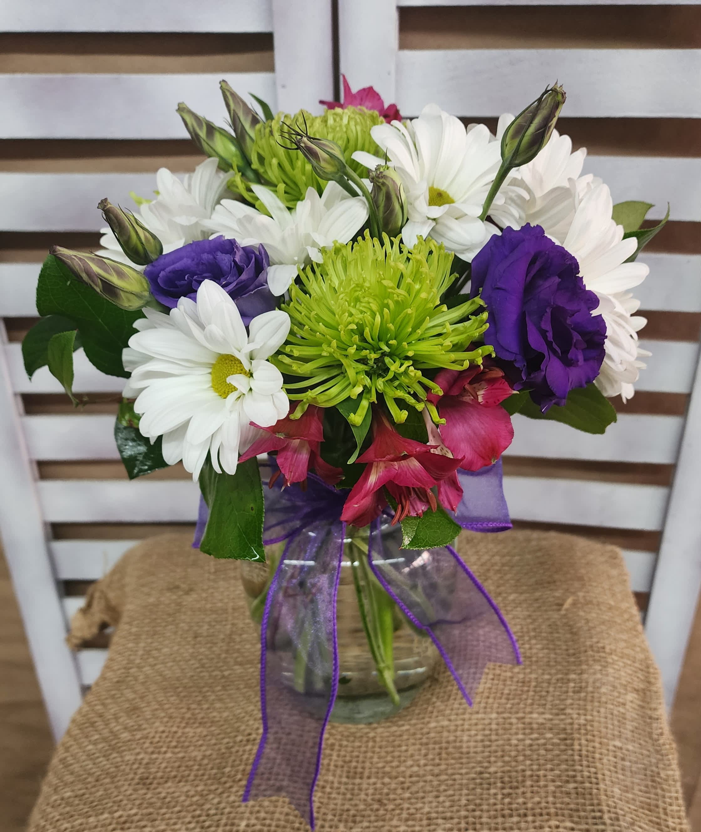 Fresh Beginnings - Hot pink alstroemerias, lime green fugis and vibrant purple lisianthus pop against bright white daisies bring a feeling of freshness to this arrangement. 