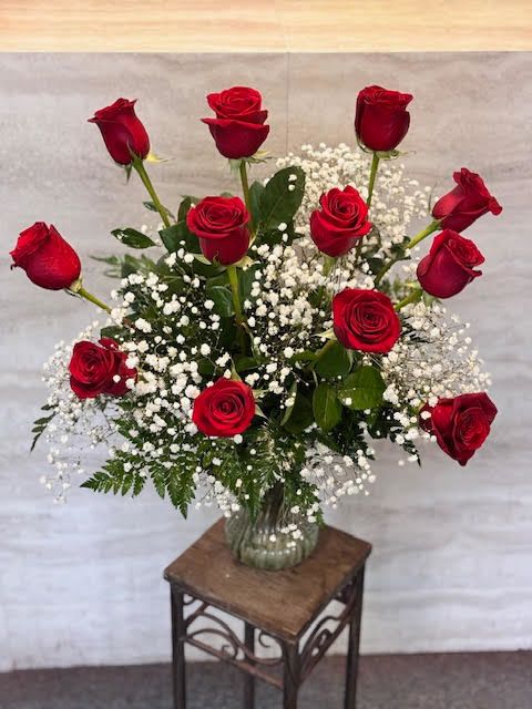 12 red roses - A classic arrangement of vibrant red roses accented with delicate baby’s breath and fresh greenery, elegantly displayed in a clear glass vase—perfect for expressing love, admiration, or celebrating any special occasion. 