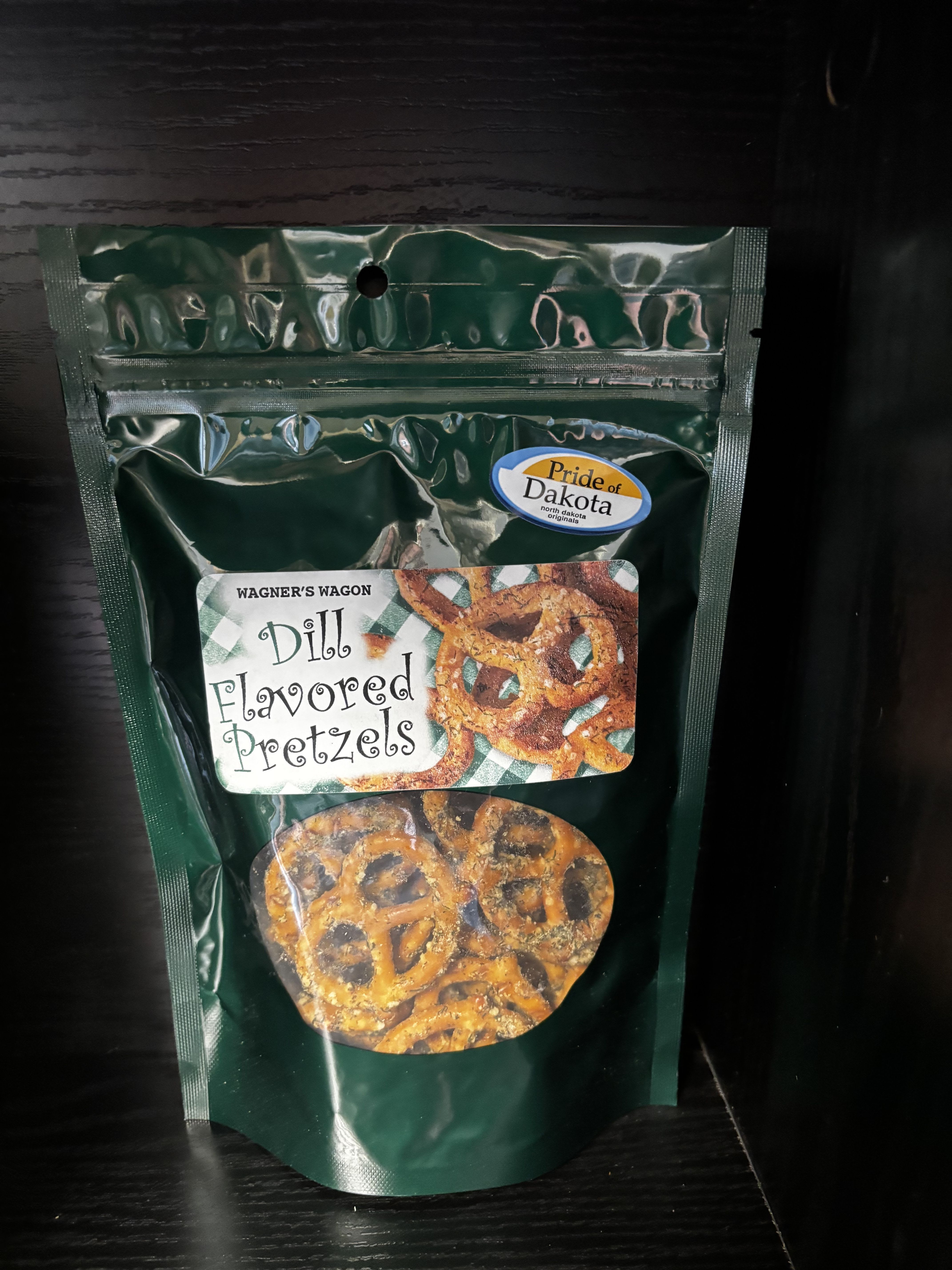 Wagner’s Wagon Dill Flavored Pretzels - Crunchy, golden pretzels seasoned with a bold and tangy dill blend that delivers big flavor in every bite. Wagner’s Wagon Dill Flavored Pretzels strike the perfect balance of savory, zesty, and salty, making them a standout snack for dill lovers. Proudly made in North Dakota and featuring Pride of Dakota products, they’re perfect for snacking, entertaining, or adding to gift baskets with a local touch.
