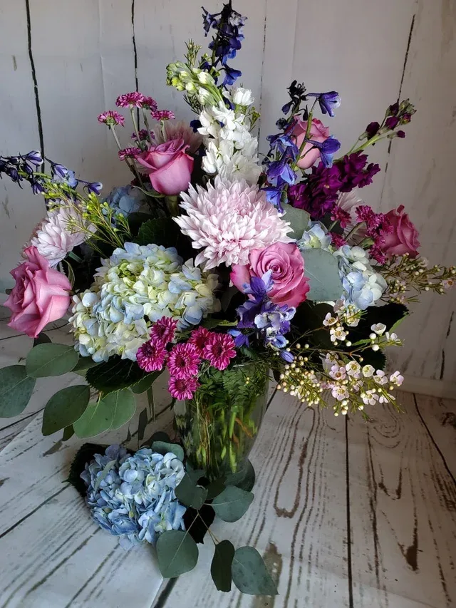 Watercolor - The watercolor style and delicate design of this arrangement make it a fitting choice for sending condolences to a memorial or funeral service, or for expressing sympathy at home. Its timeless elegance ensures that it will always convey your heartfelt sentiments with grace and compassion.  Please note, these photos are meant to serve as an inspiration for color and style. Due to the seasonality of flowers, these arrangements cannot always be identically replicated.   Please contact us at 607-257-3203 with any questions.