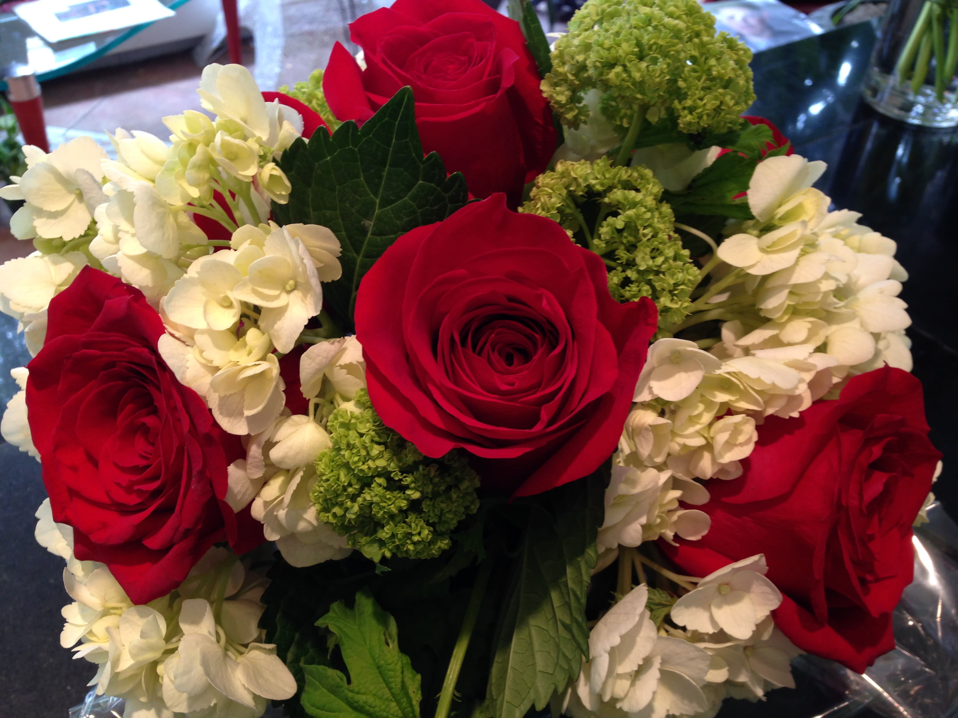 Can't Take My Eyes Off of You - Romantic and unique arrangement of red roses, with a bed of white and green flowers.