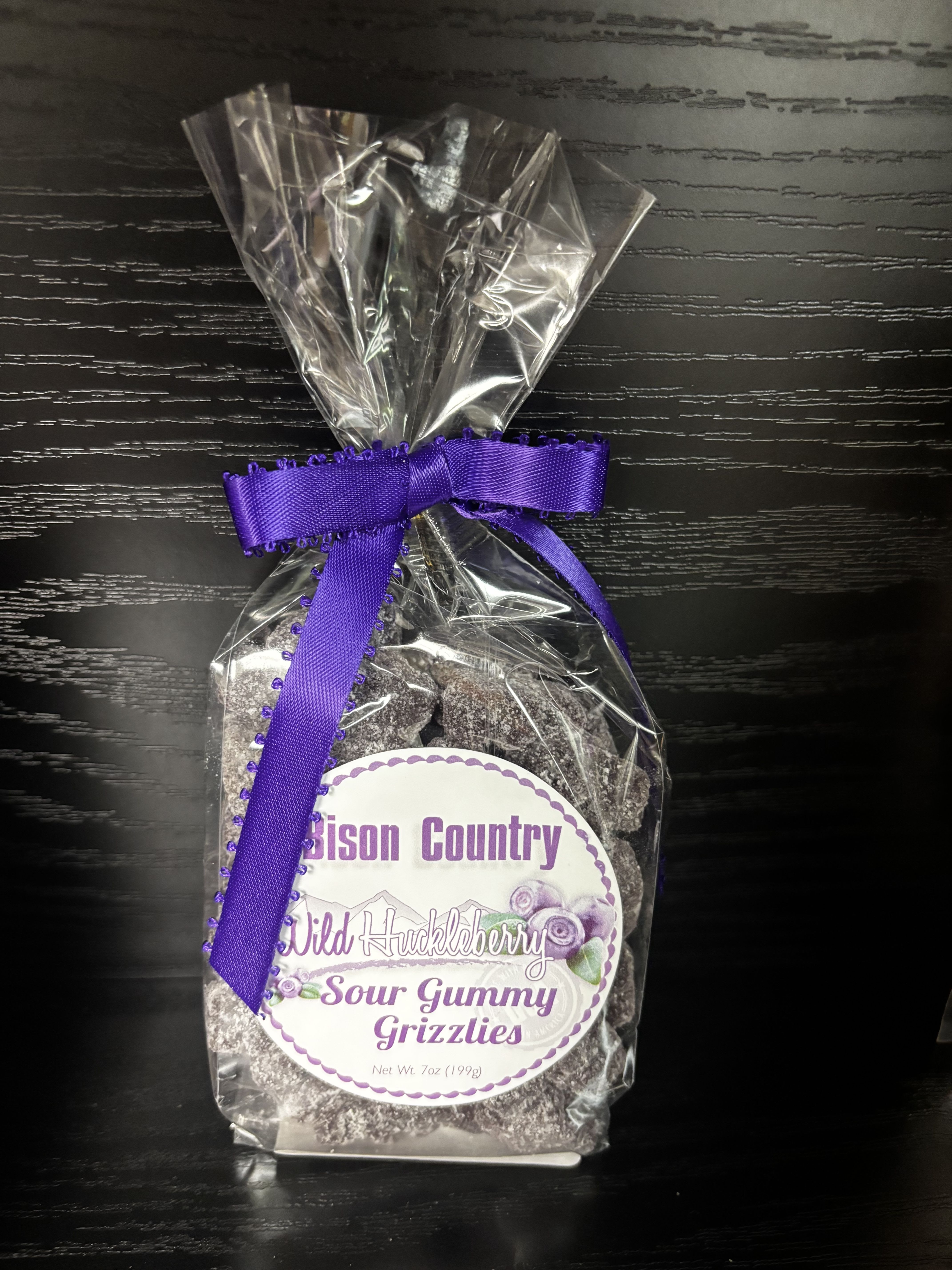 Bison Country Wild Huckleberry Sour Gummy  - Huckleberry Sour Gummy Grizzlies from Bison Country. Soft, chewy gummy bears are infused with bold wild huckleberry flavor, then coated with a light sour sugar for the perfect puckery kick. The result is a mouthwatering balance of sweet berry goodness and zesty tang. Perfect for candy lovers who enjoy a little extra zing—great for snacking, gifting, or adding a fun pop to any candy display.