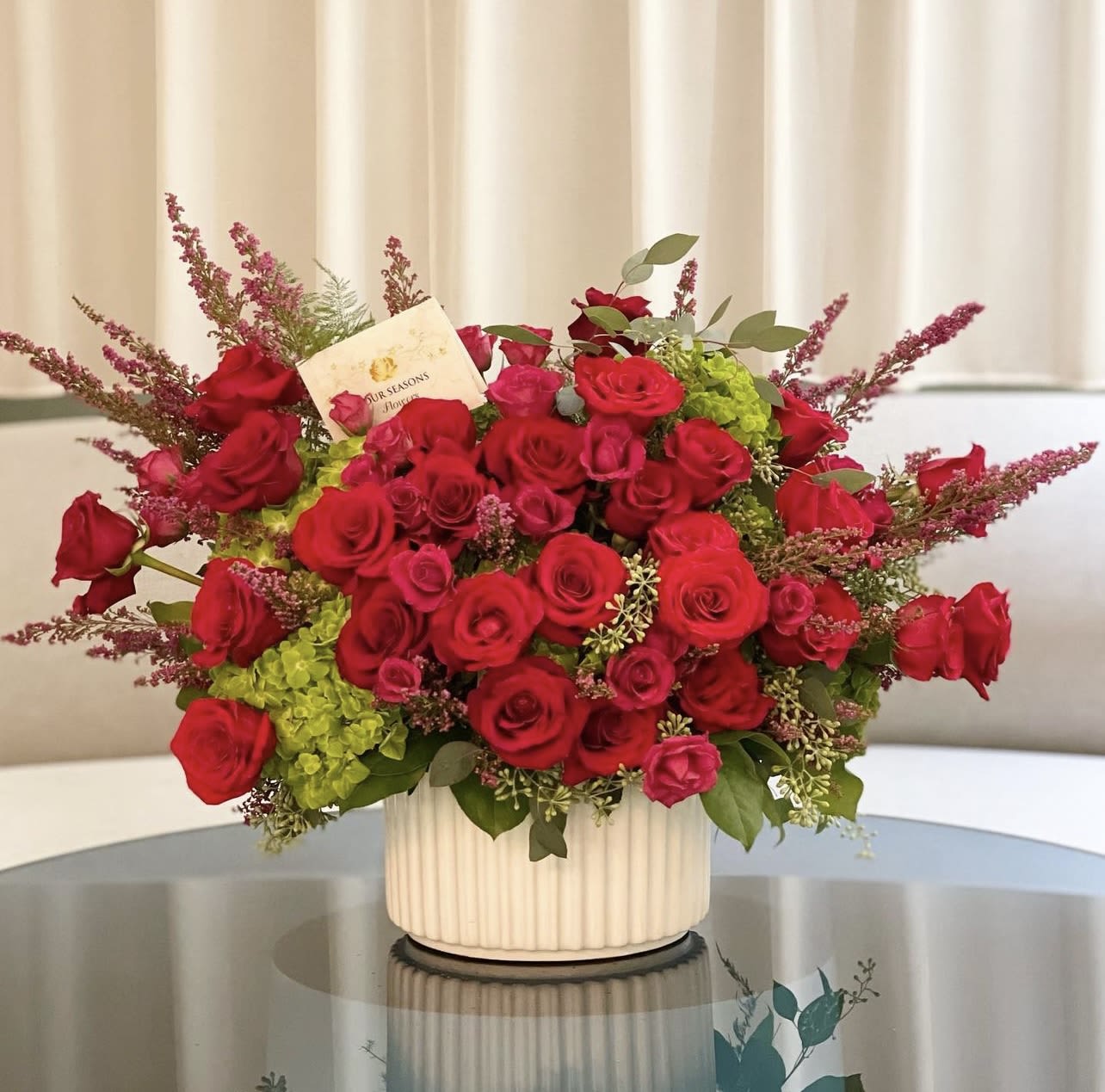 Ruby Red - Asymmetric modern composition with red roses accented with subtle pops of greens  Some florals are seasonal, if particular flower will not be available due to season, we will substitute for similar flower, composition, color pallet and value of the arrangements as closely as possible. All effort to create a floral arrangement as close to the photo shown, the actual arrangement may vary slightly in its appearance from the photo shown. If you have any questions about your order, we welcome you to call us in or email  