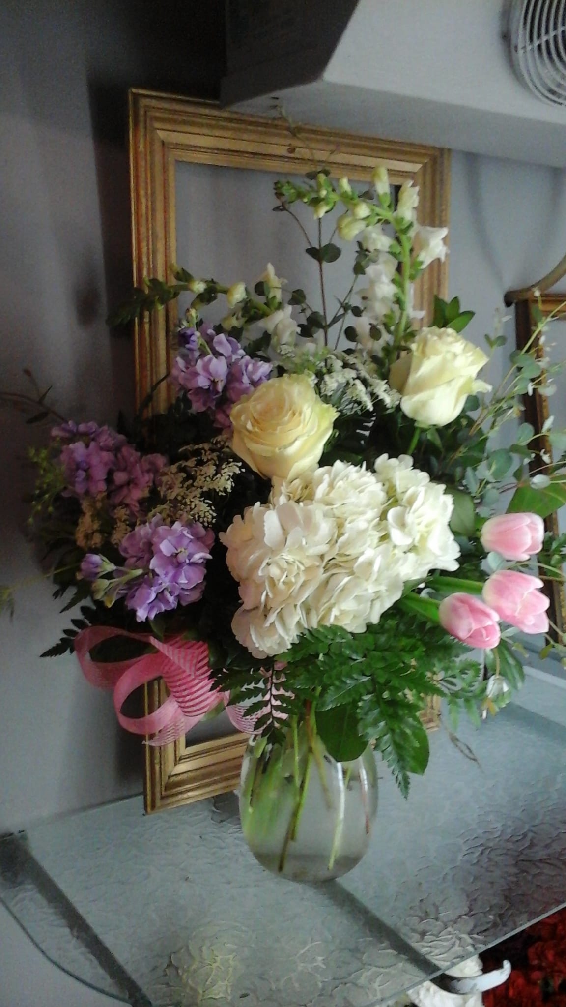 " Sherri's - One Fine Day " - Evoke the gentle beauty of a perfect spring day with this lovely arrangement, featuring soft pink tulips, lush white hydrangeas, elegant white roses, and fragrant lavender stock for a touch of subtle purple charm. A harmonious blend of pastel tones and fresh blooms—ideal for birthdays, celebrations, or brightening any space with seasonal joy.  