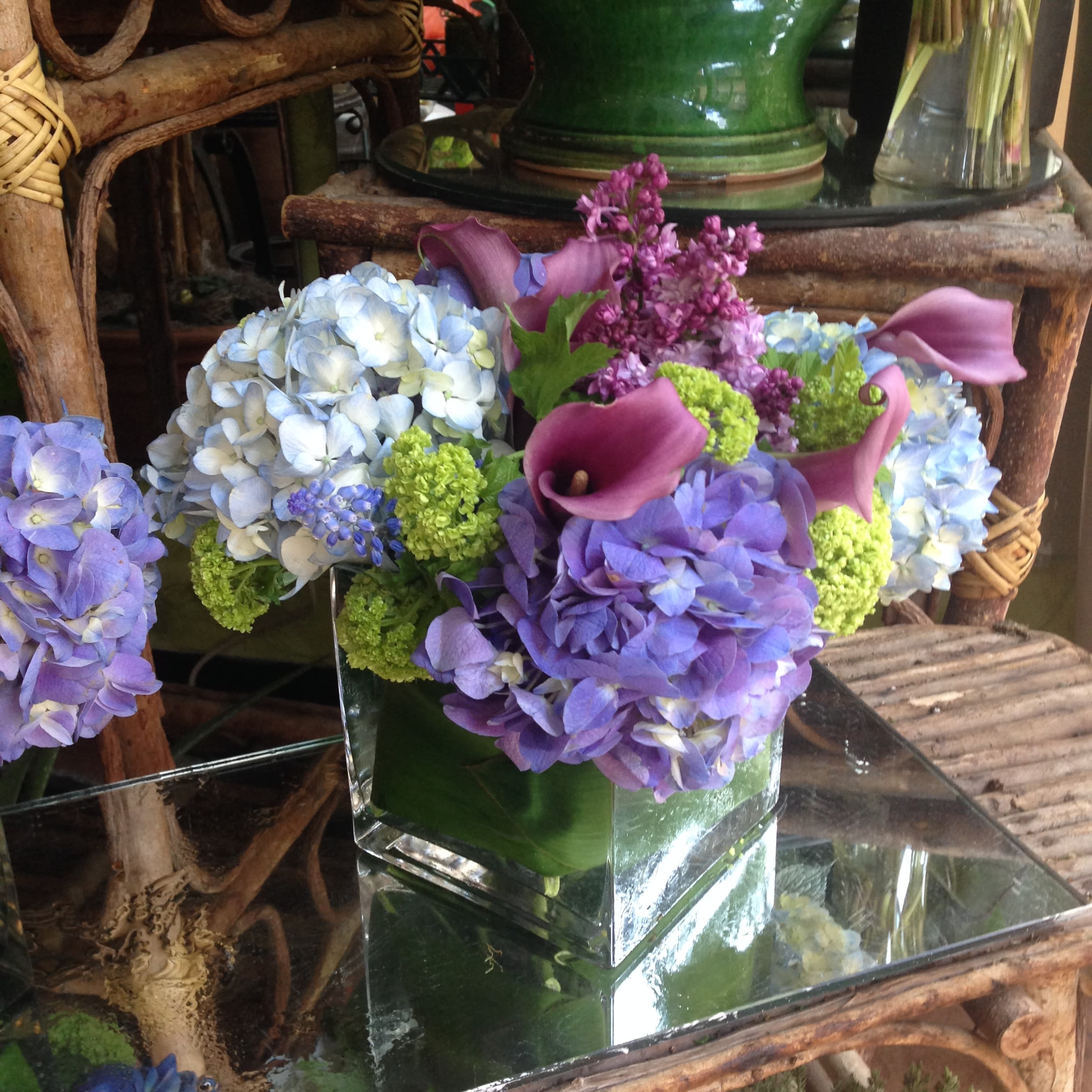 Blue Jasmine - A sensitive and artistic assembly of green, purple, and blue flowers.  Note: lilac is only available in the spring.