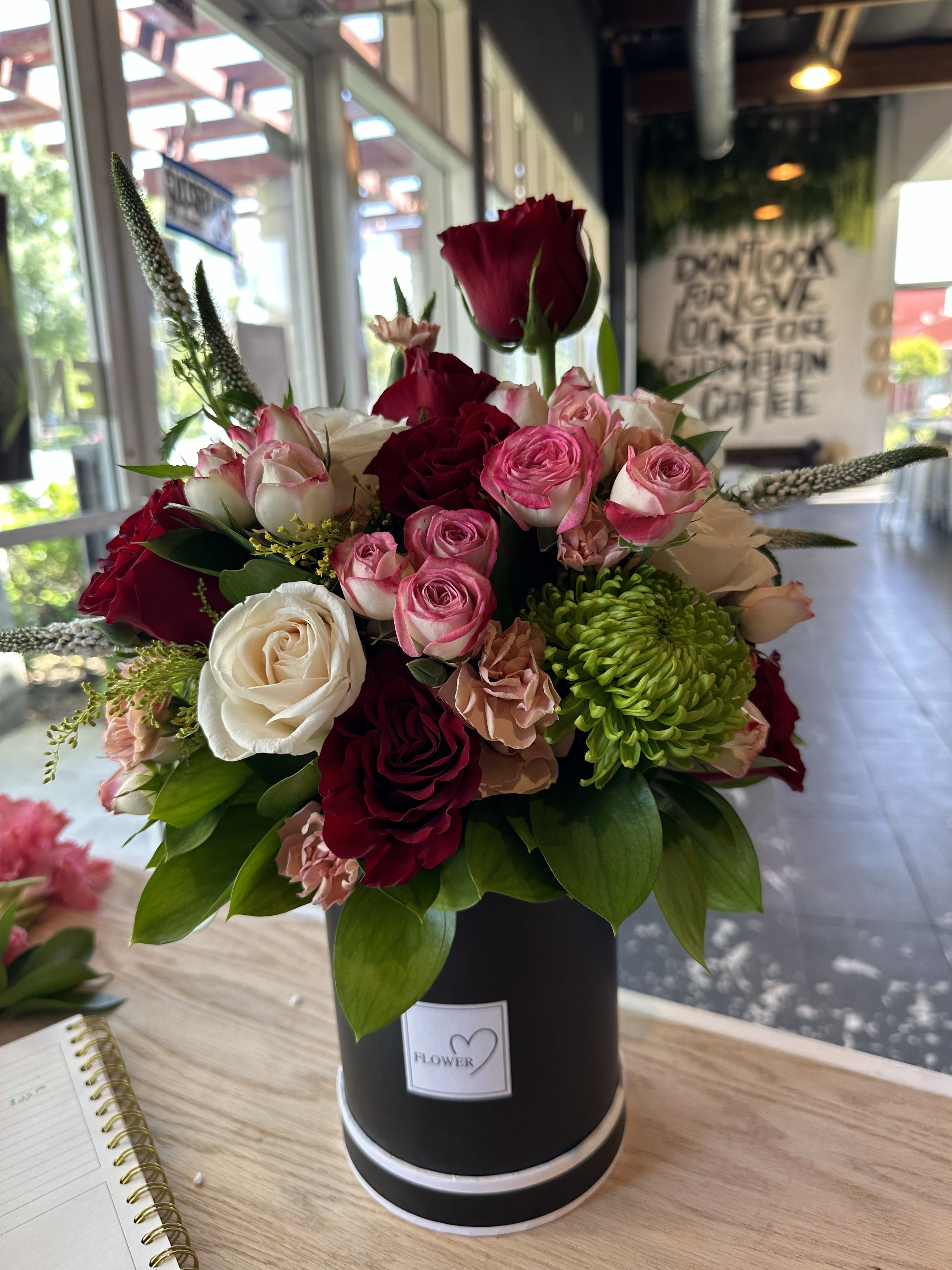 Crimson Grace - Crimson Grace is a rich and elegant floral arrangement designed in a matte black flower box, featuring a romantic blend of deep red roses, soft blush and white roses, delicate accent blooms, fresh greenery, and seasonal textures.  This arrangement combines passion and softness, making it a perfect choice for anniversaries, romantic gestures, celebrations, or meaningful gifts that speak from the heart. Its lush composition and bold color contrast create a timeless and luxurious statement.  Each arrangement is handcrafted with care using fresh, premium flowers. Flower varieties may vary slightly depending on seasonal availability while preserving the overall style and color palette   Red, blush, and white premium roses 	•	Seasonal accent flowers and greenery 	•	Elegant matte black flower box 	•	Handcrafted and ready to gift 