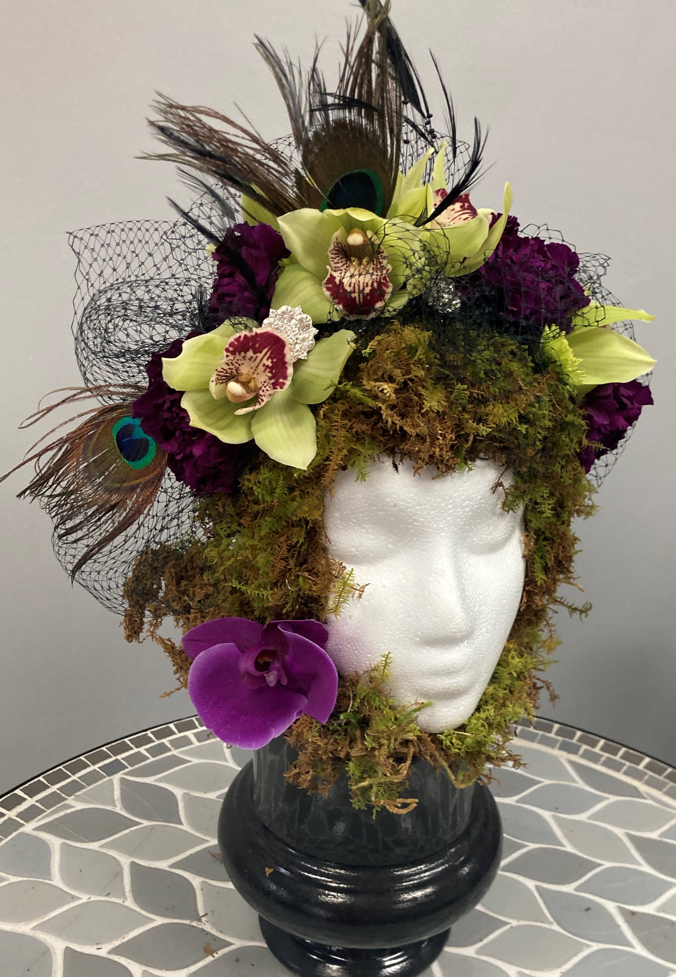 Hat's Off - A unique kind of floral arrangement, unlike any other. Adorned in orchids and blooms and mosses.