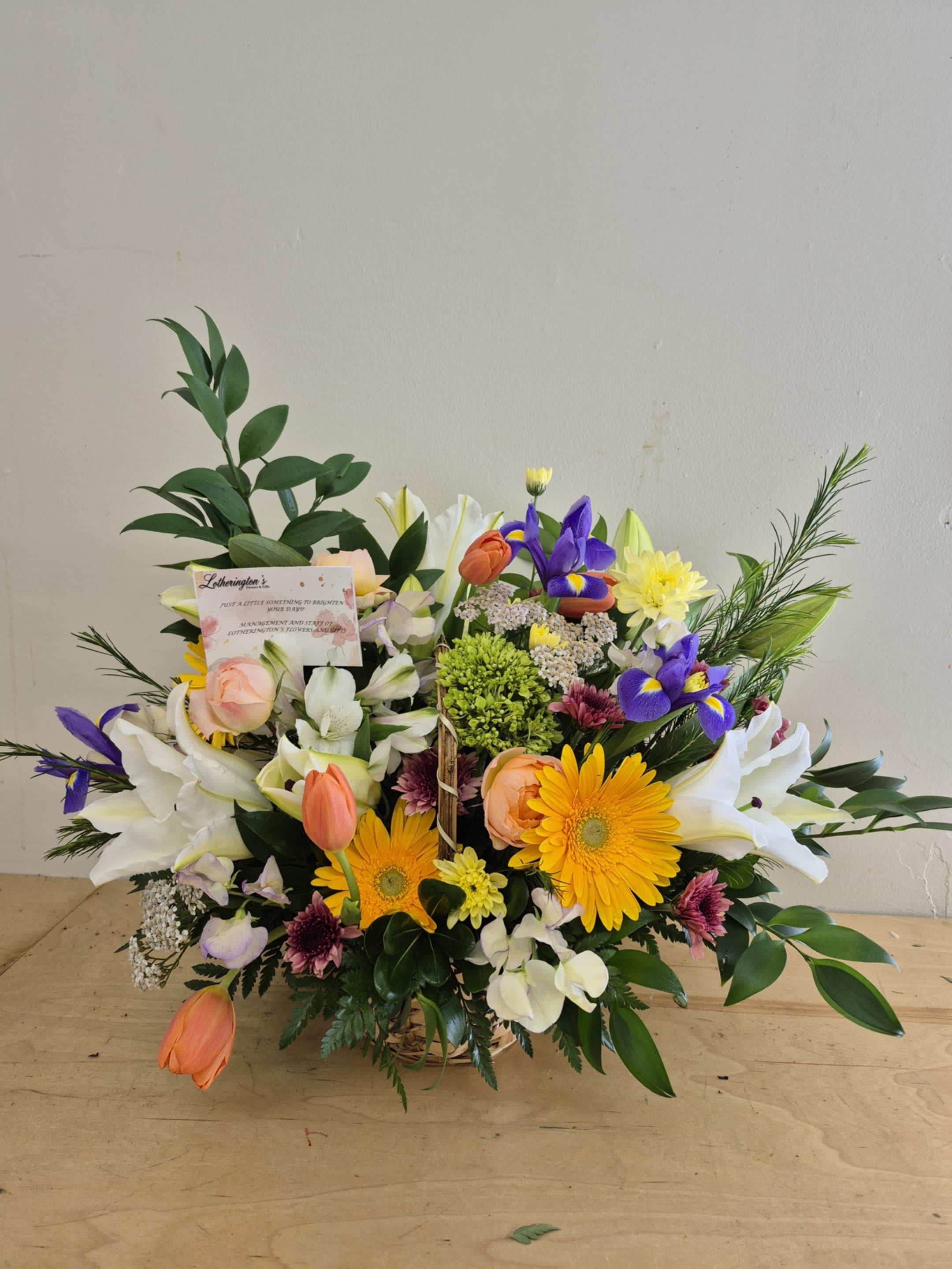 Bright Morning by Lotherington's - White, yellow and green  with a touch of blue come together with green hydrangea for a bright basket of sunshine. This arrangement lights up any space and will improve anybody's day. A perfect gift for all occasions.   APPROXIMATE DIMENSIONS 10" W X 11" H 