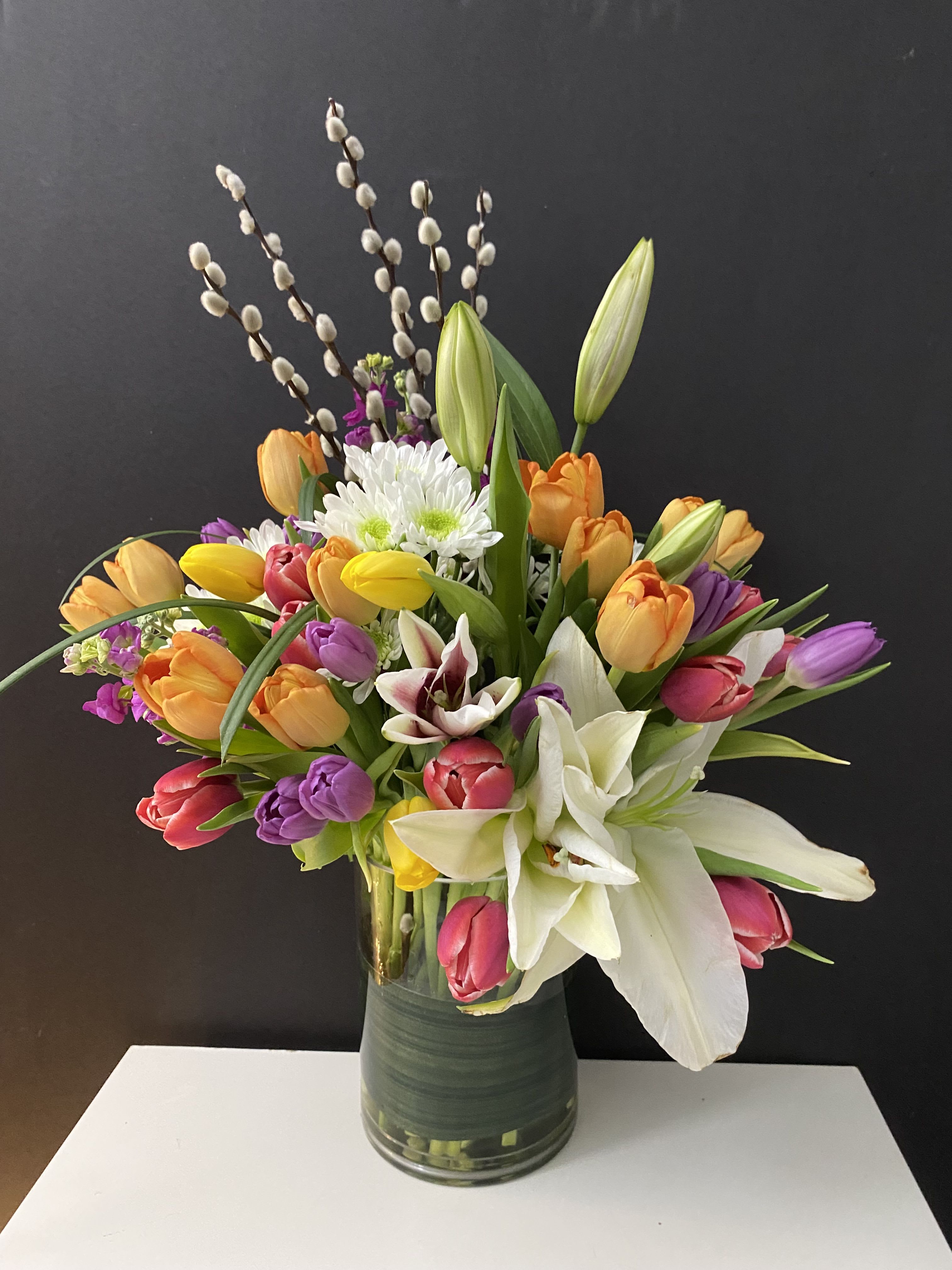 Season Accent  - Tulips, Stock, Mums, Lilies, Pussy Willow in glass 6”x 8” vase 