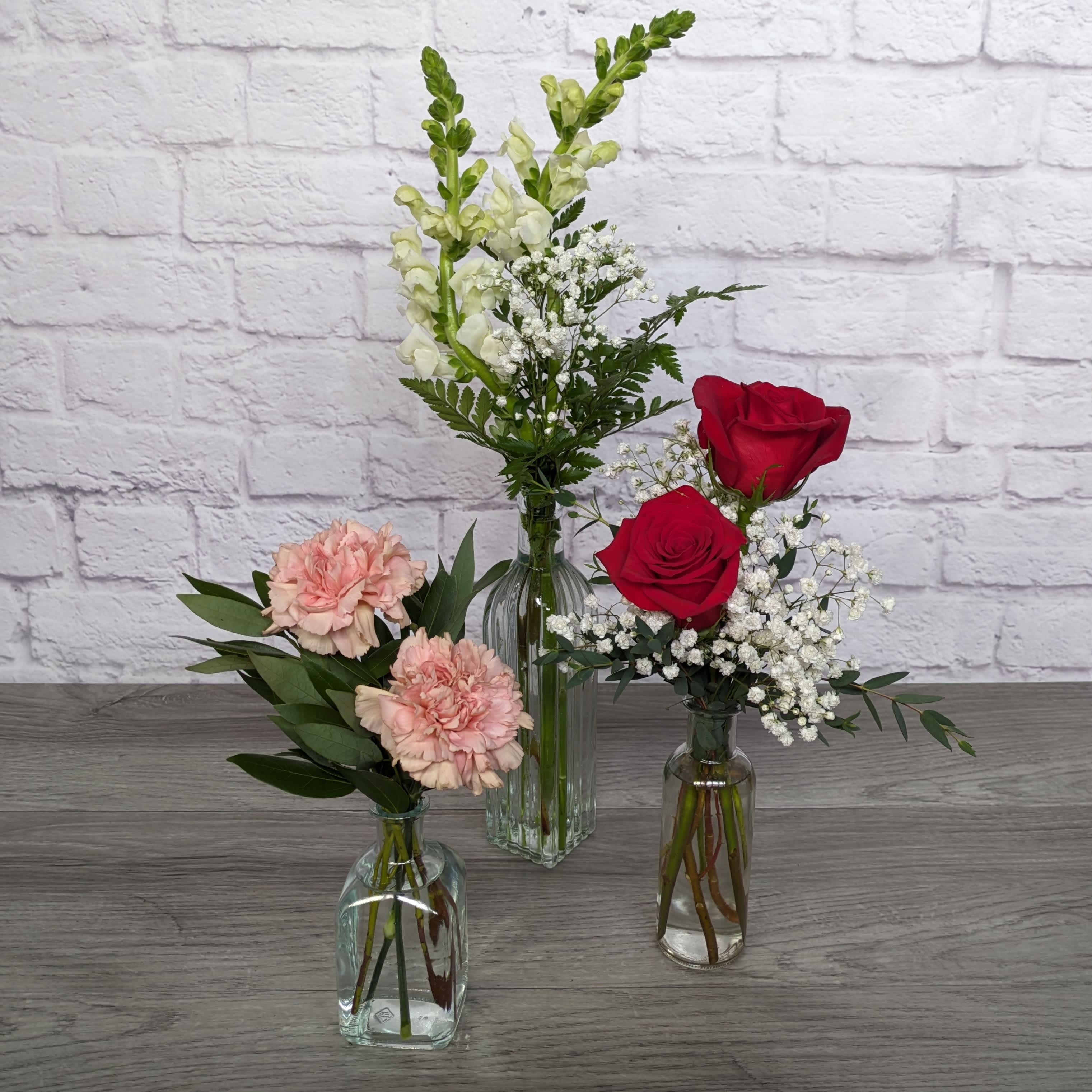 Bottled Love - Bottled Love is A Ladybug Floral exclusive valentines bouquet. An eclectic assortment of vases and flowers in shades of white, pink and red.   All Round Orientation 21"H  *Due to high demand during valentine's week lilies may arrive in bud form. With proper care and watering they will open. Some colors may be substituted, however we will maintain the same overall look and feel of the original bouquet.* 