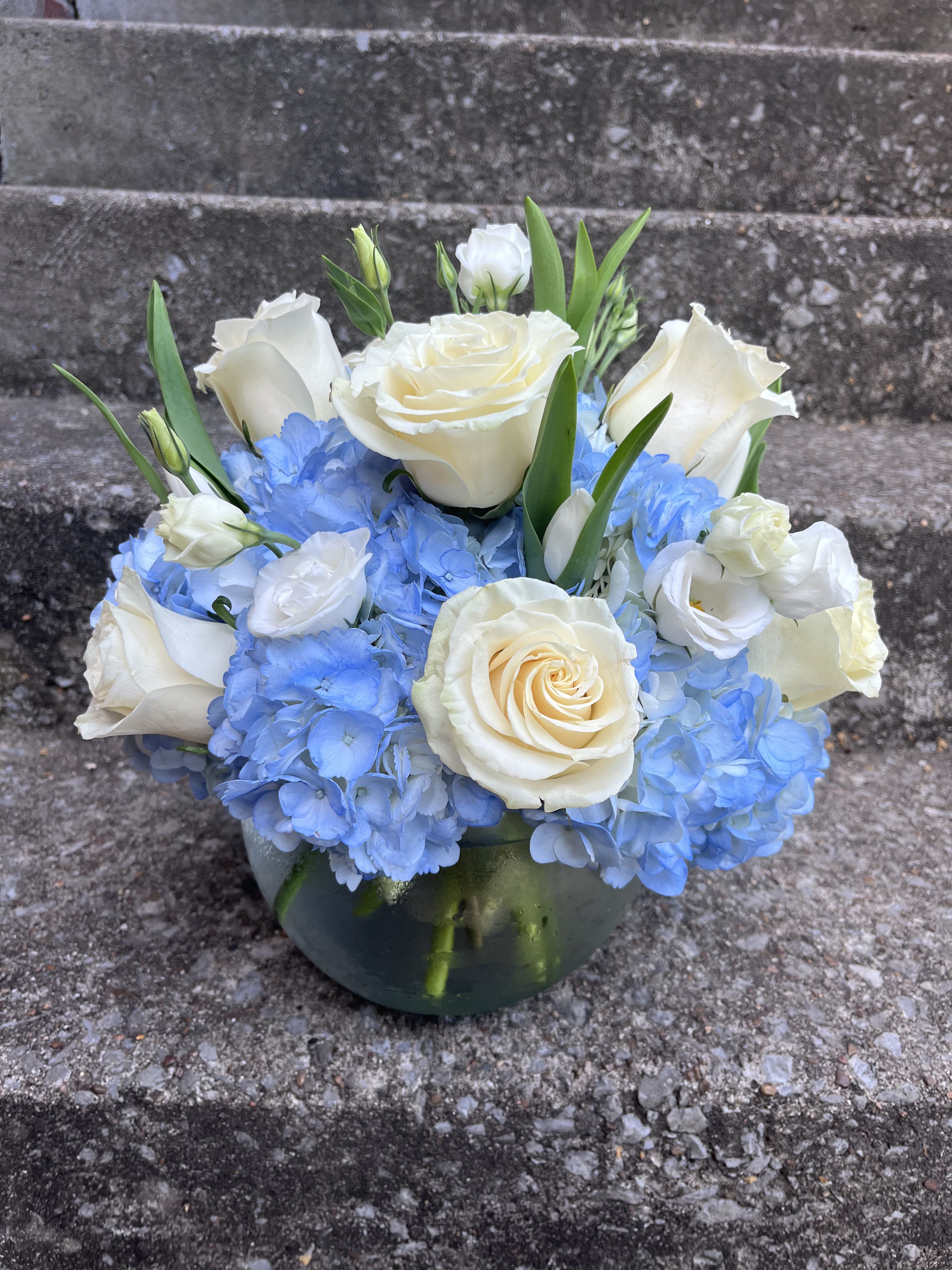 Misty Blue  - This arrangement has roses, hydrangeas, tulips, and lisianthus. The picture shown above is the deluxe. 