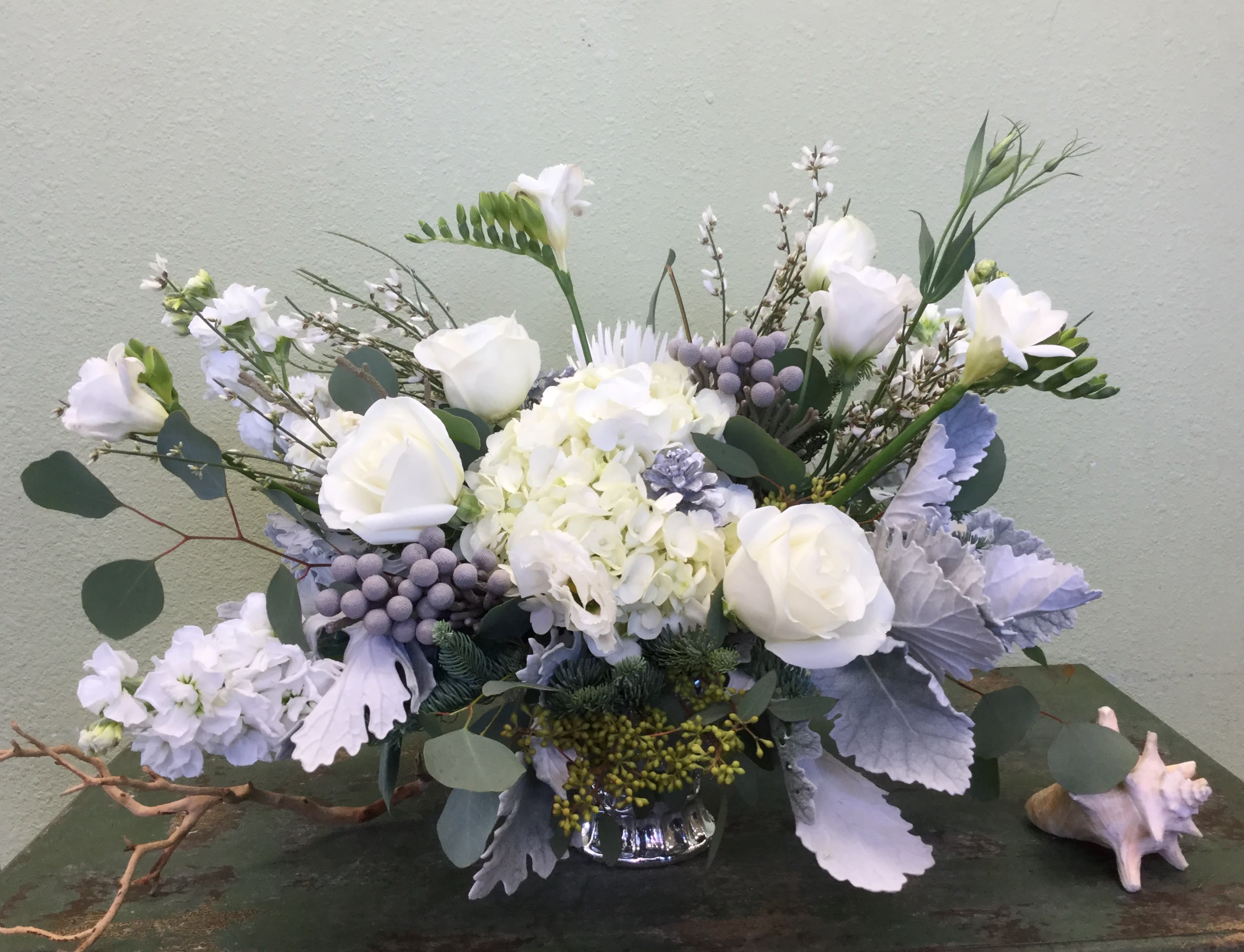 Silver Elegance - Modern and stunning, this new holiday design features premium white blooms and gorgeous silver accents. This breathtaking arrangement will bring elegance to your holiday.  Flowers and container may vary, please call if this is a concern. 