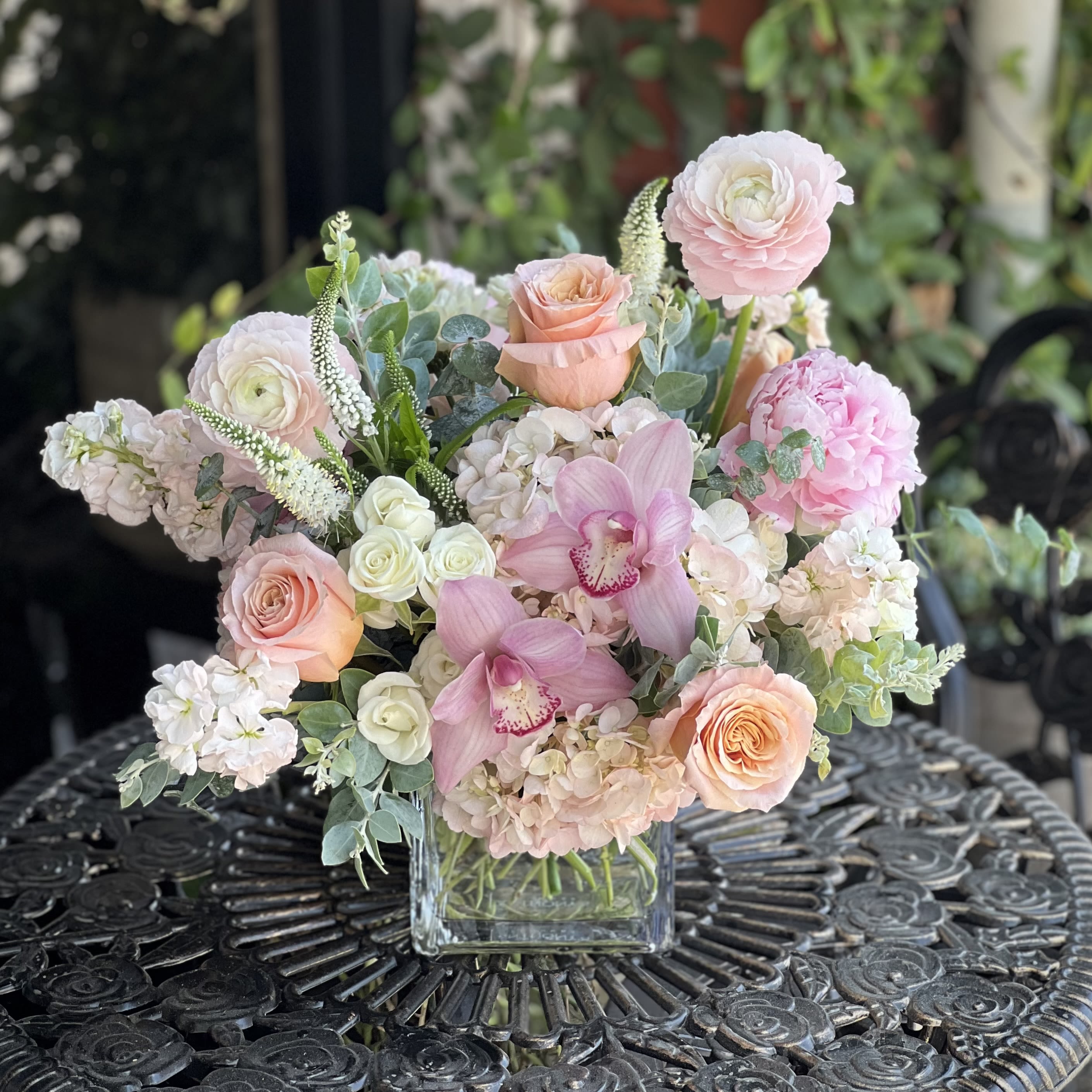 Peaches &amp; Cream (Peonies!) - Elegant, lush, and undeniably gorgeous—Peaches &amp; Cream is a dreamy mix of soft blush, peach, and ivory blooms. Featuring cymbidium orchids, peonies, ranunculus, roses and sprays, veronica, and hydrangeas, this arrangement is designed in a modern 5x5" glass cube vase and accented with fresh eucalyptus. Arrangement approximately measures 16" wide and 15" tall with flowers.