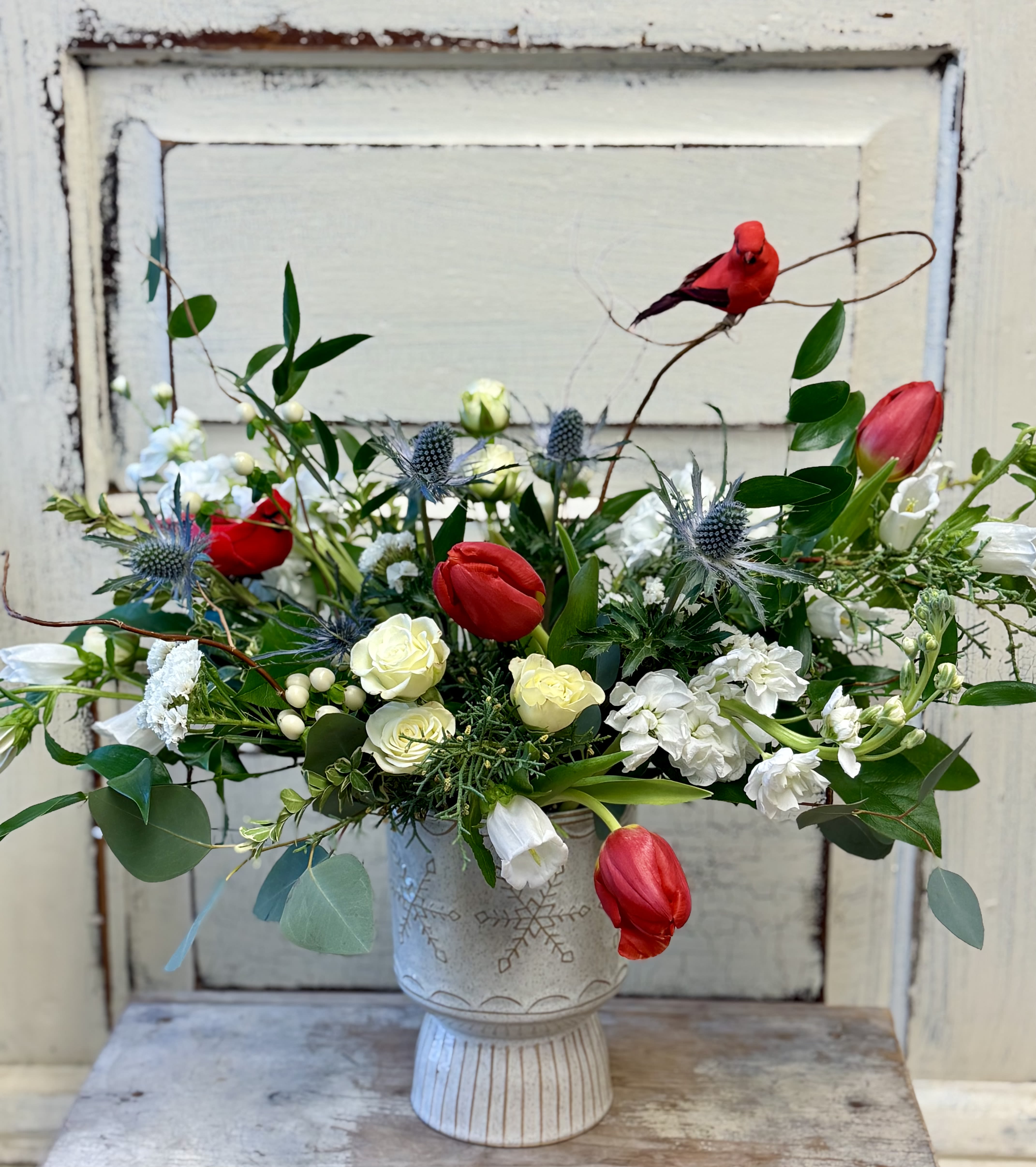 Love and Hope - Send well wishes for the winter season and the coming year. This gorgeous design in a larger keepsake ceramic container is designed with assorted foliage, fresh tulips, spray roses and much more. Two cardinals are tucked into the arrangement as symbols of hope and love.