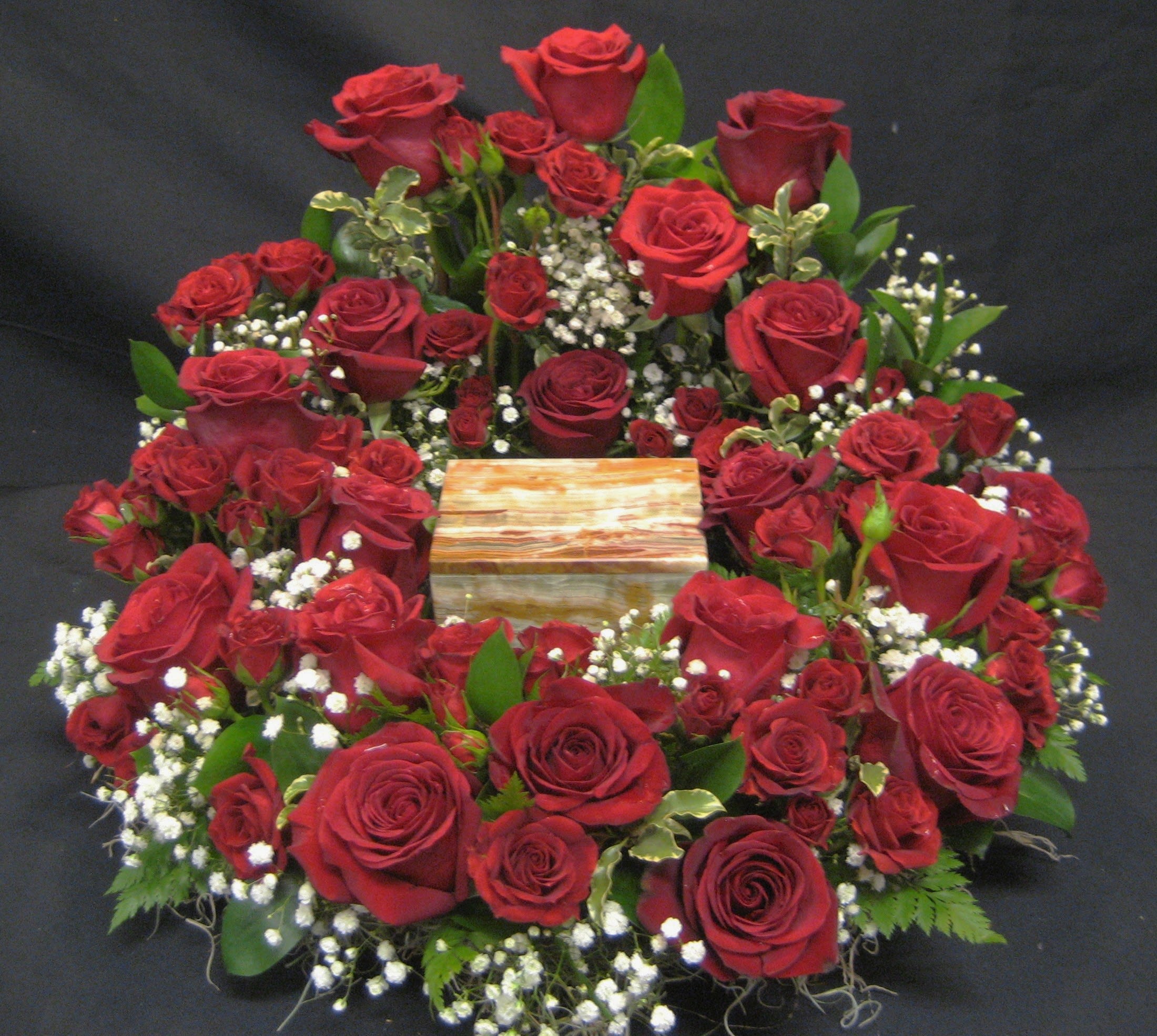 All Rose Urn Wreath U3 - This collection of standard and miniature roses is rich and royal. Available in any color rose and finished with babies breath and accenting foliage, it's the perfect tribute to a rose lover.
