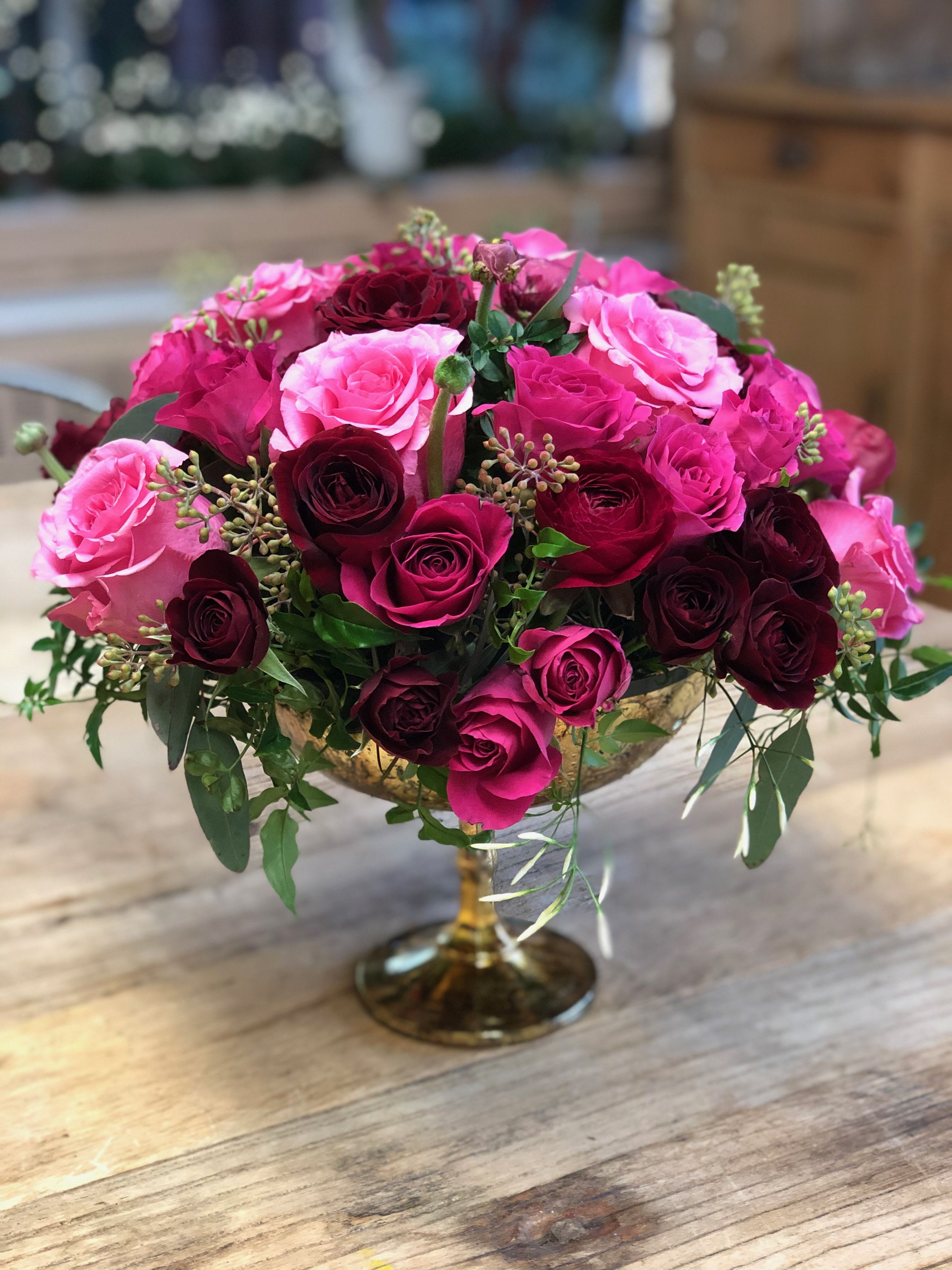 Love is in the Air  - Stunning arrangement!! Arranged in a beautiful gold pedestal vase with an abundance of hot pink &amp; burgundy roses with touches of seeded eucalyptus. Romantic and elegant! 