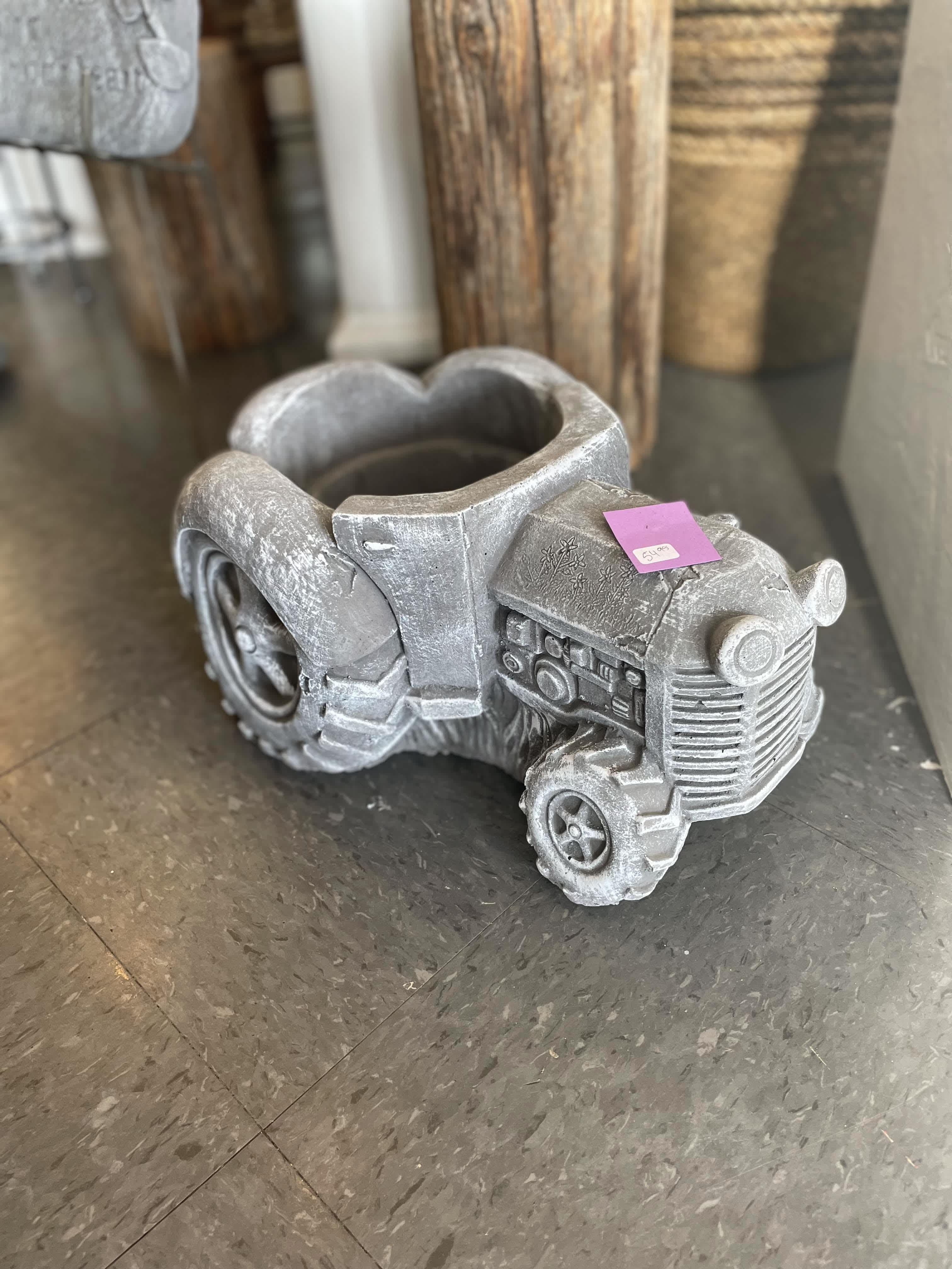 Tractor Stone Planter - A tractor stone planter. The price listed includes the price of the stone, along with $50 worth of flowers added to it. If you want a specific style or color of flowers, just write it in the special notes! If not, we will just fill the planter with a nice mixture of seasonal flowers. 