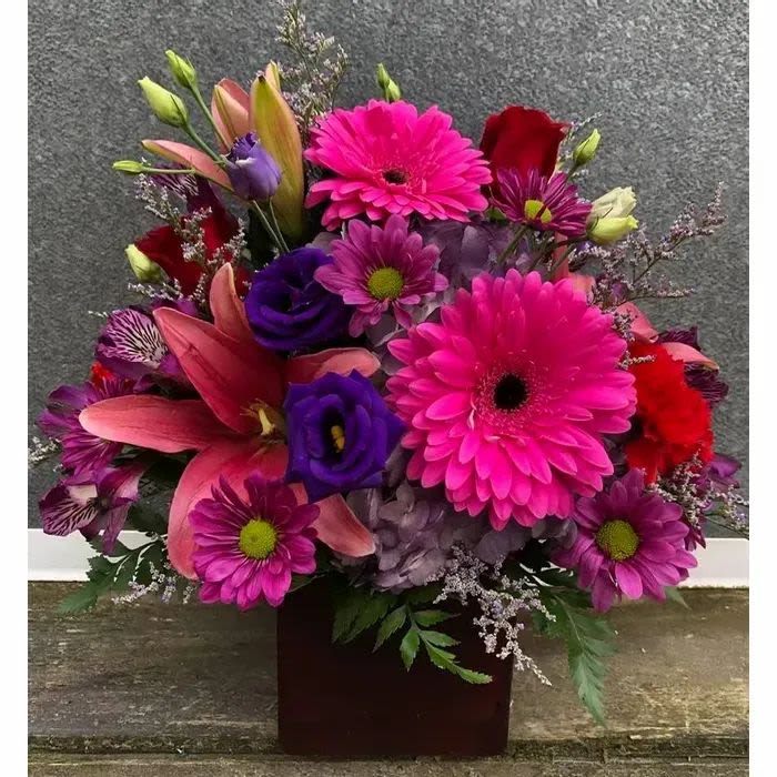 Midtown Magenta Jewel Box - Make someone’s day sparkle with this vibrant mix of magenta, purple, and red flowers, hand-designed by a local Omaha florist. This bold square-vase arrangement features bright gerbera daisies, roses, lilies, hydrangeas, and seasonal accent blooms with premium greenery. Perfect for Omaha same day flower delivery if ordered by 12 noon this design is ideal for birthdays, anniversaries, congratulations, thank you gifts, Valentine’s Day, Mother’s Day, or to add fresh color to any Omaha home or office.  ***** Cube arrangements are short and compact********