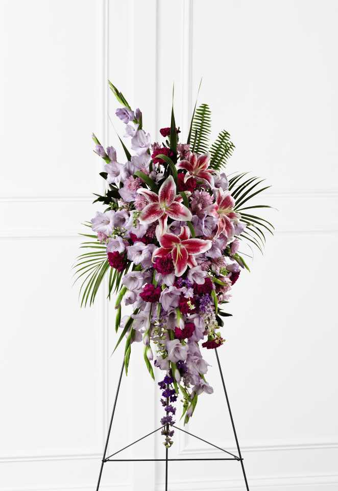 The FTD Tender Touch Standing Spray S33-4513 - The FTD Tender Touch Standing Spray creates an elegant display of beauty and color to enhance their final tribute. Lavender gladiolus, Stargazer lilies, fuchsia carnations, purple larkspur, lavender Peruvian lilies, lavender chrysanthemums, sword fern fronds, emerald palm fronds and other assorted greens are gorgeously arranged to create a sophisticated standing spray. Displayed on a wire easel, this arrangement will add to the sophistication of their service with each fragrant bloom.